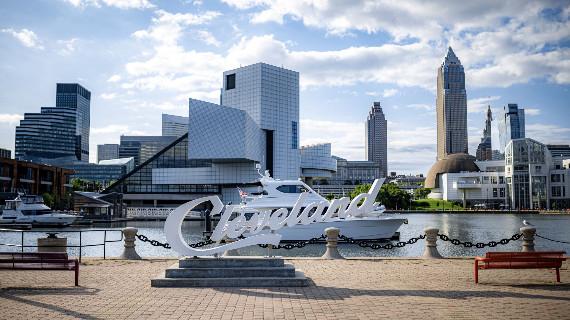 Image of script Cleveland sign with Rock Hall and Cleveland skyline in the background