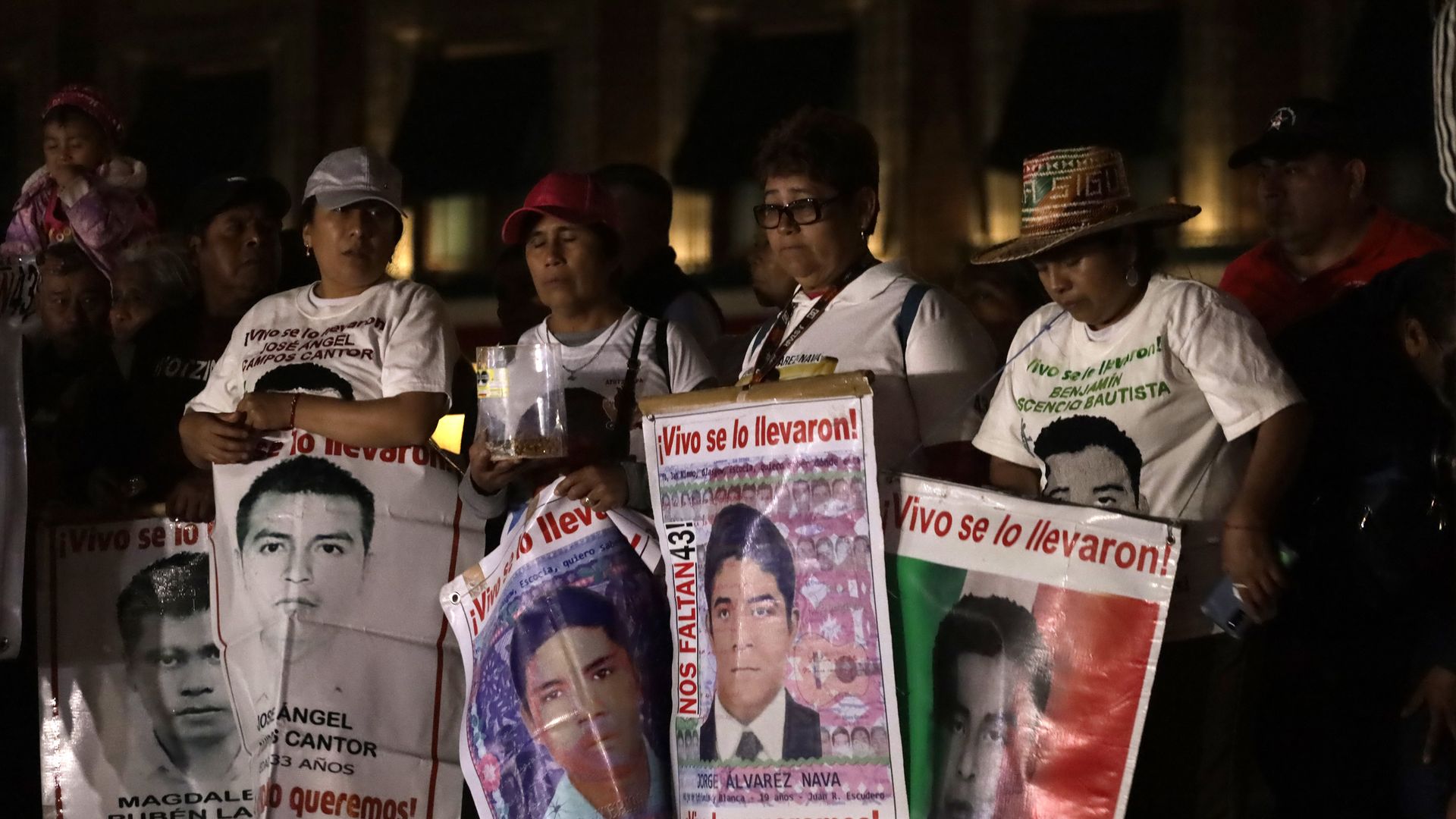 mothers hold signs of their missing sons.