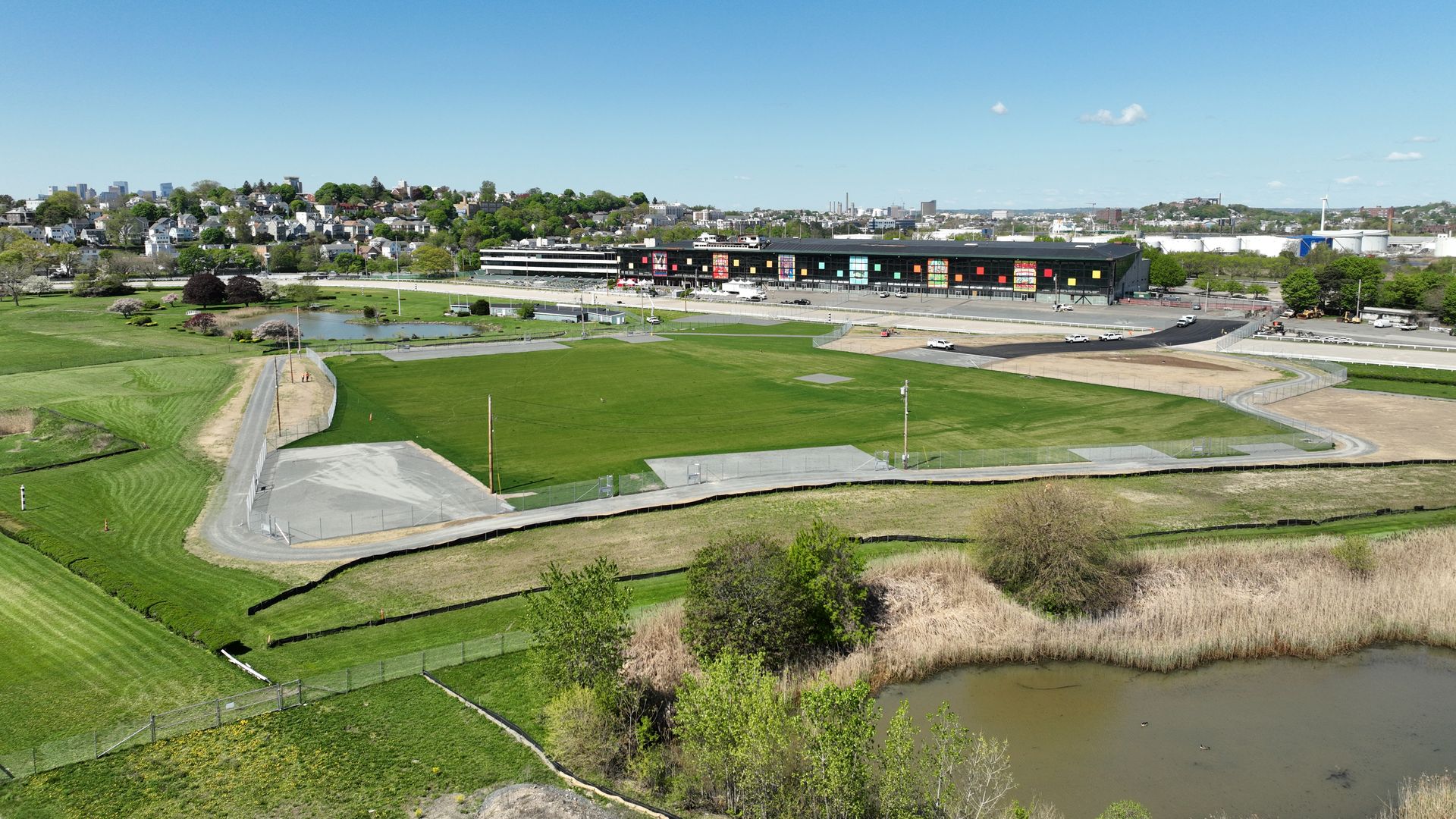 A distant wide shot showing the green space that will comprise The Stage. The gray gravel patches show where the stage of the namesake venue will be.