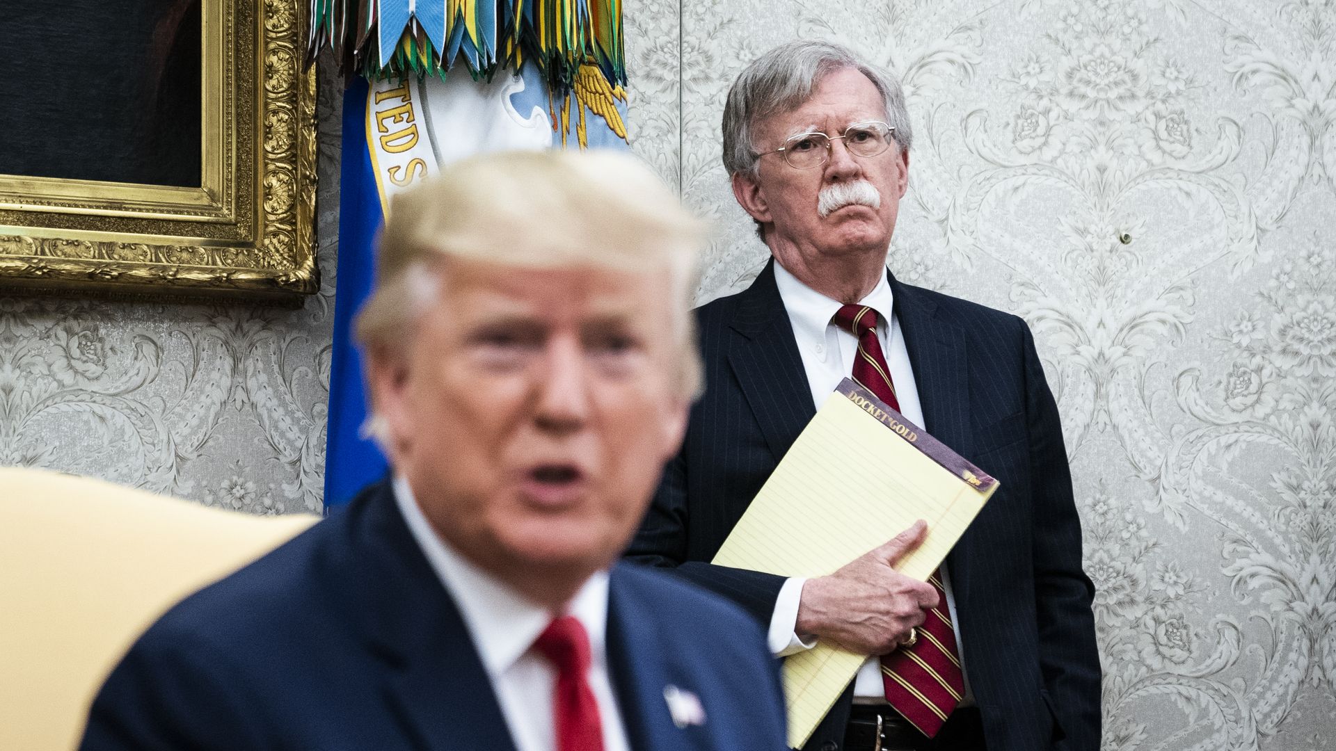 Bolton standing behind Trump