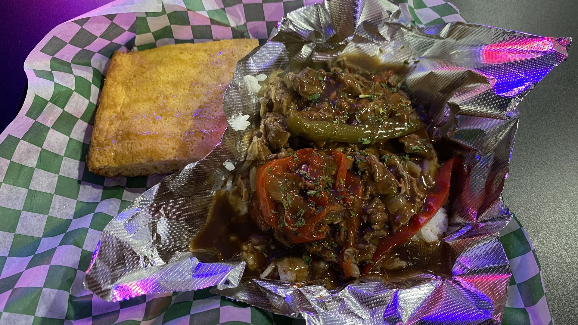 Chopped steak, red and green peppers, and gravy with a piece of cornbread. 
