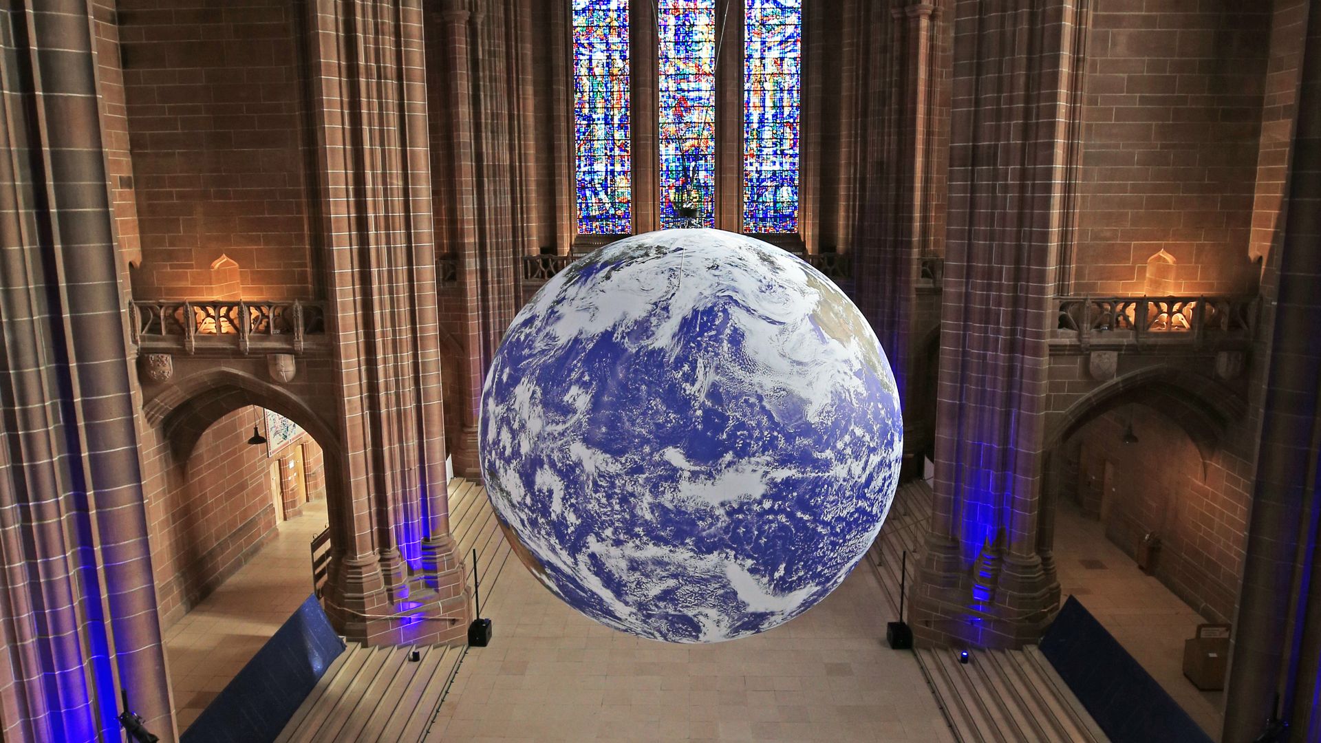 A giant replica of the earth floating in a cathedral. 