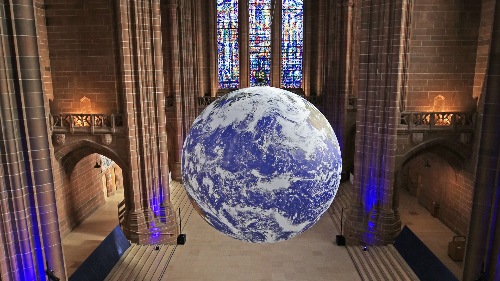 A giant replica of the earth floating in a cathedral.