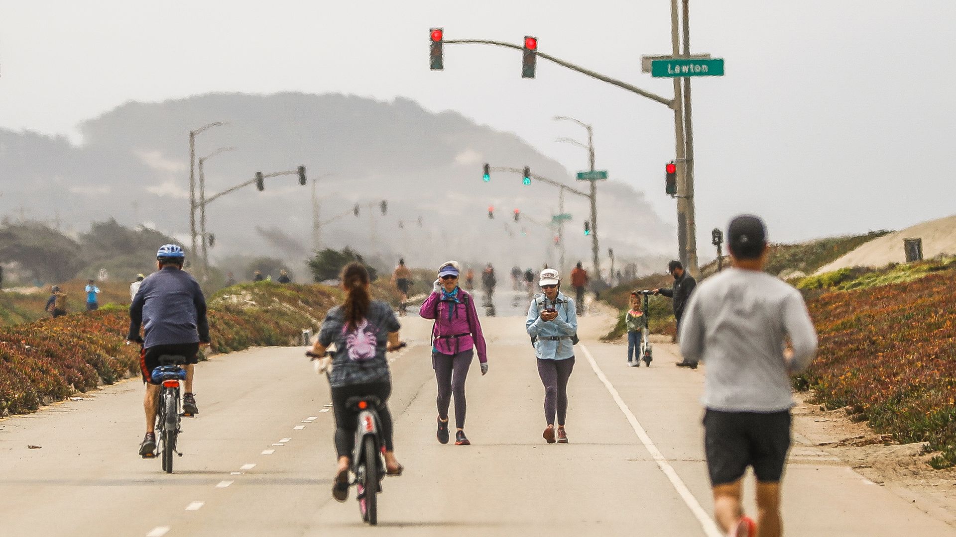 Pedestrians and bicyclists on the Great Highway park.