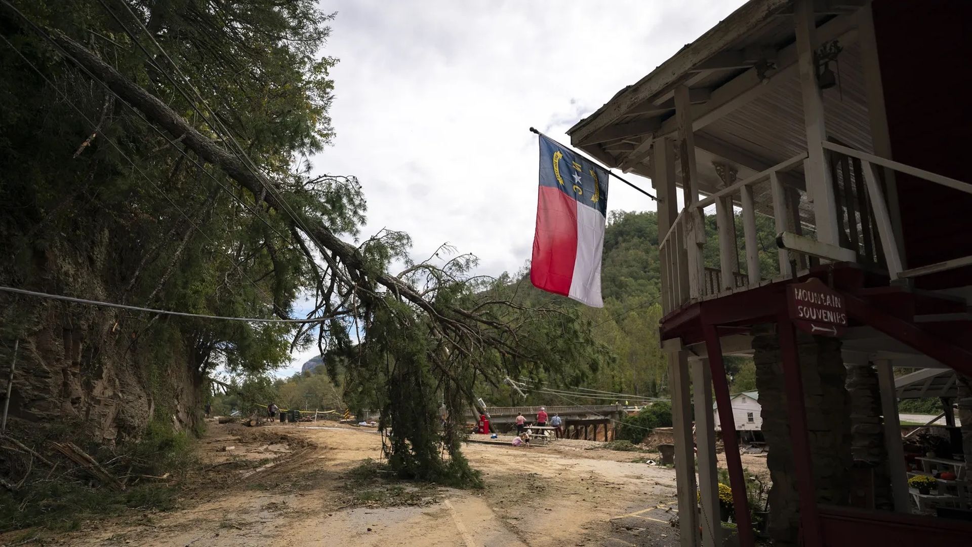 debris left behind after hurricane, north carolina flag hangs from post