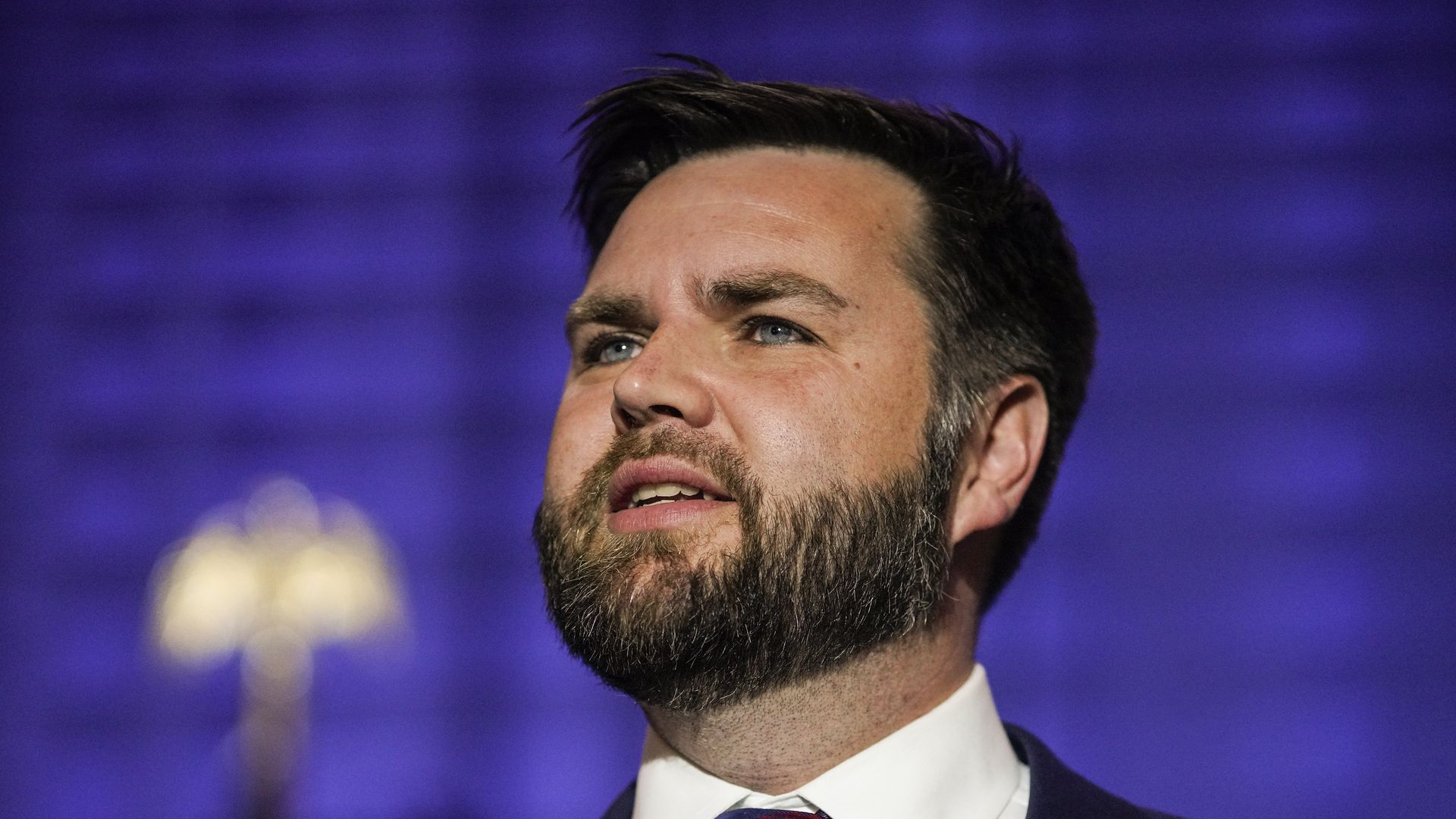 A person with a beard looks up