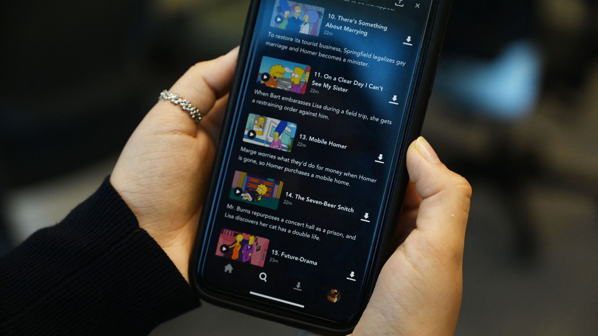 A photo illustration taken on November 29, 2021 of a mobile phone displaying the Disney+ streaming service in Hong Kong shows a list of episodes of cartoon series "The Simpsons".