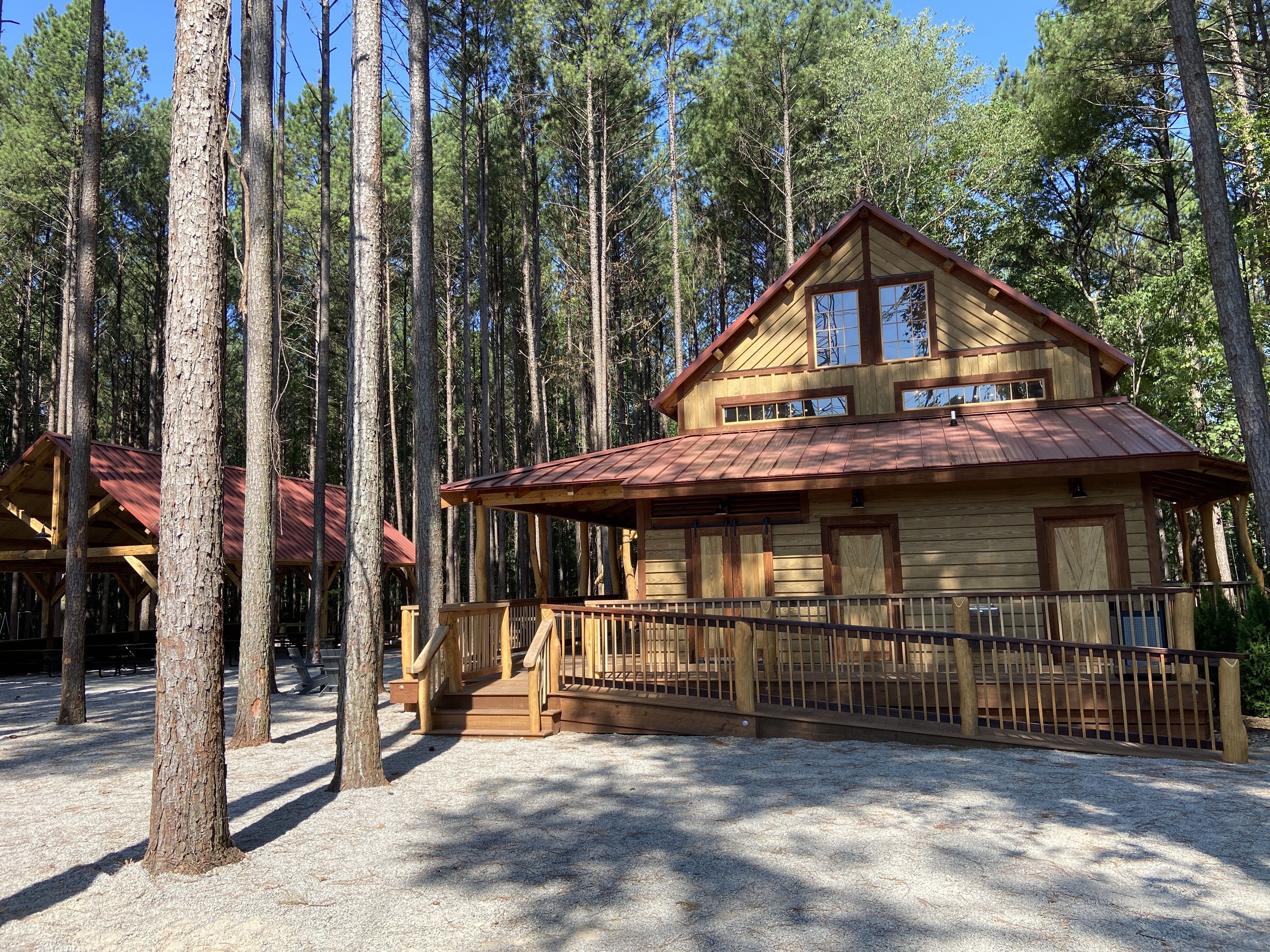 The shaded picnic pavilion and the cabin in Wildwoods at the Whitewater Center. 