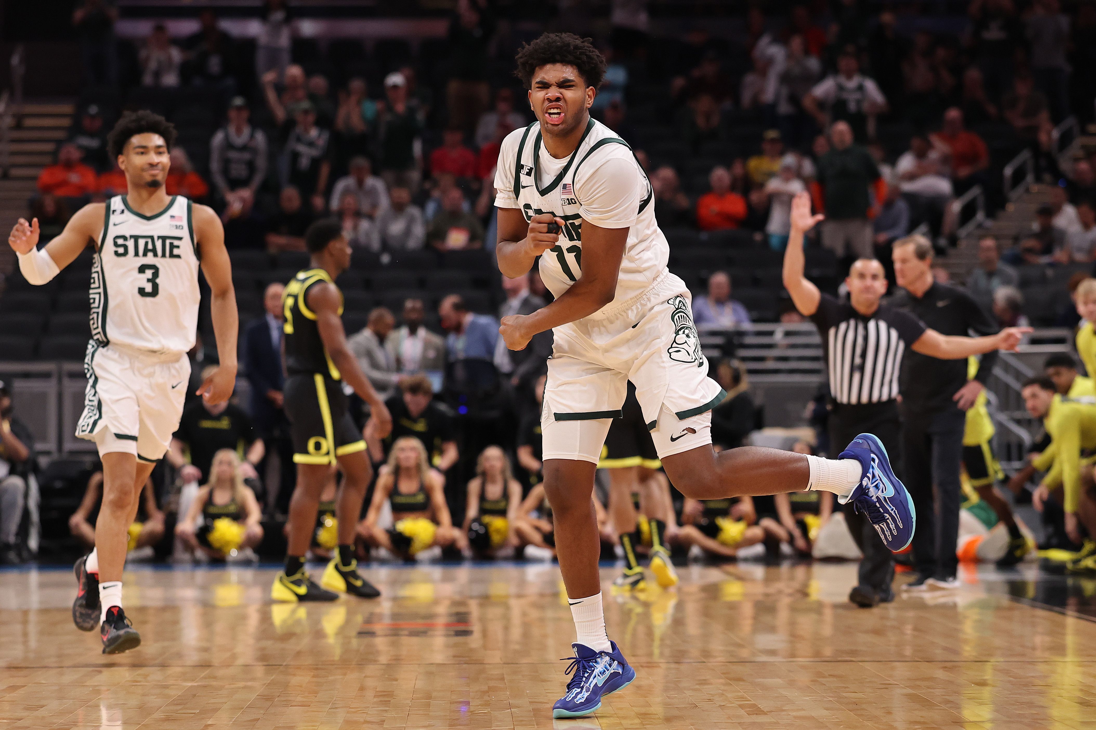 Photo of a basketball player celebrating on a court. 