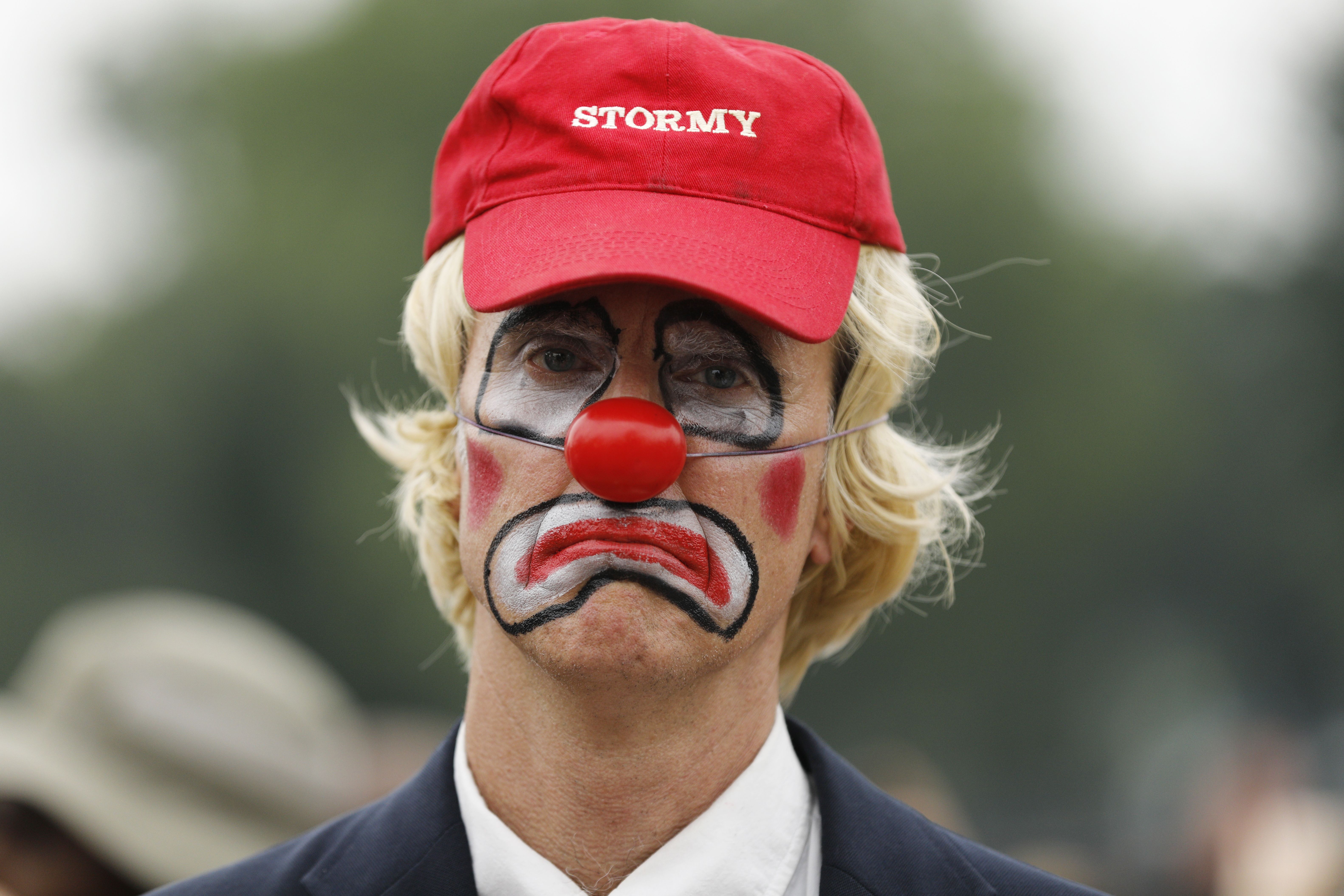 A man in clown makeup impersonates Donald Trump