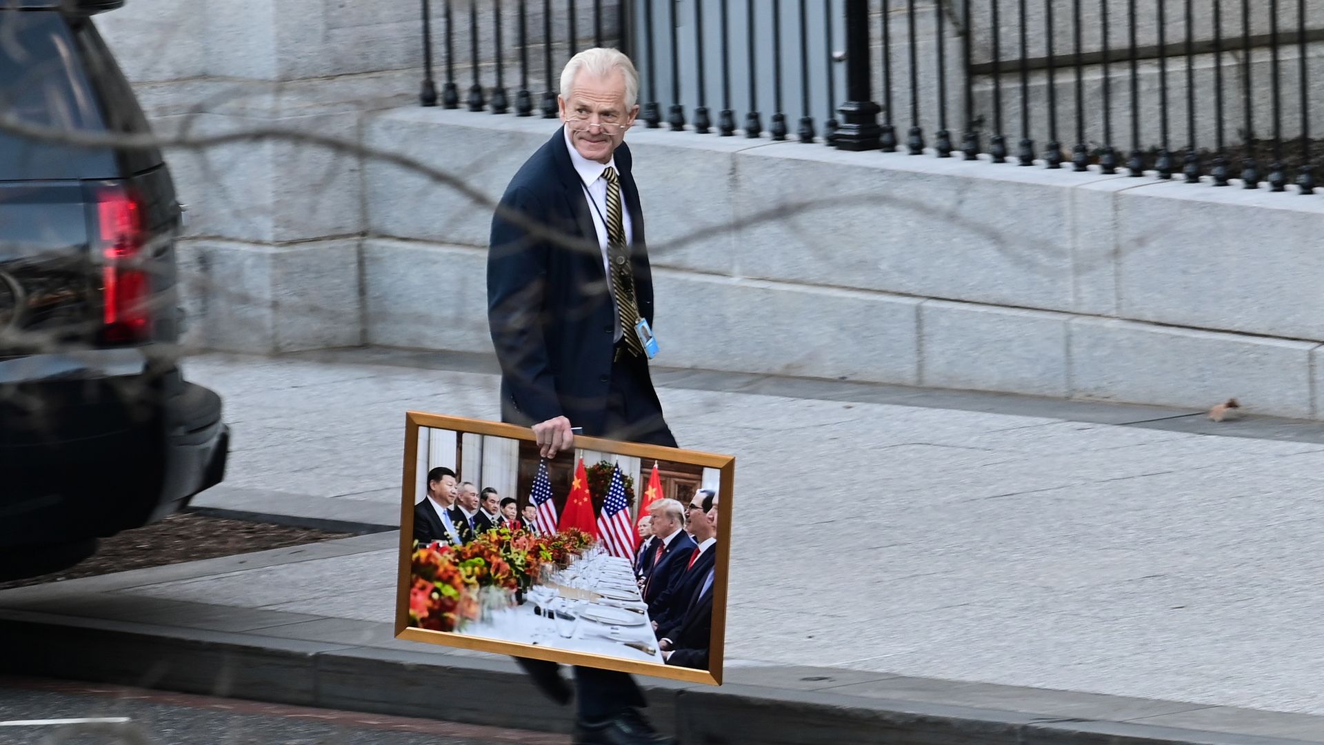 Trade Advisor Peter Navarro is seen carrying a portrait away from the White House.