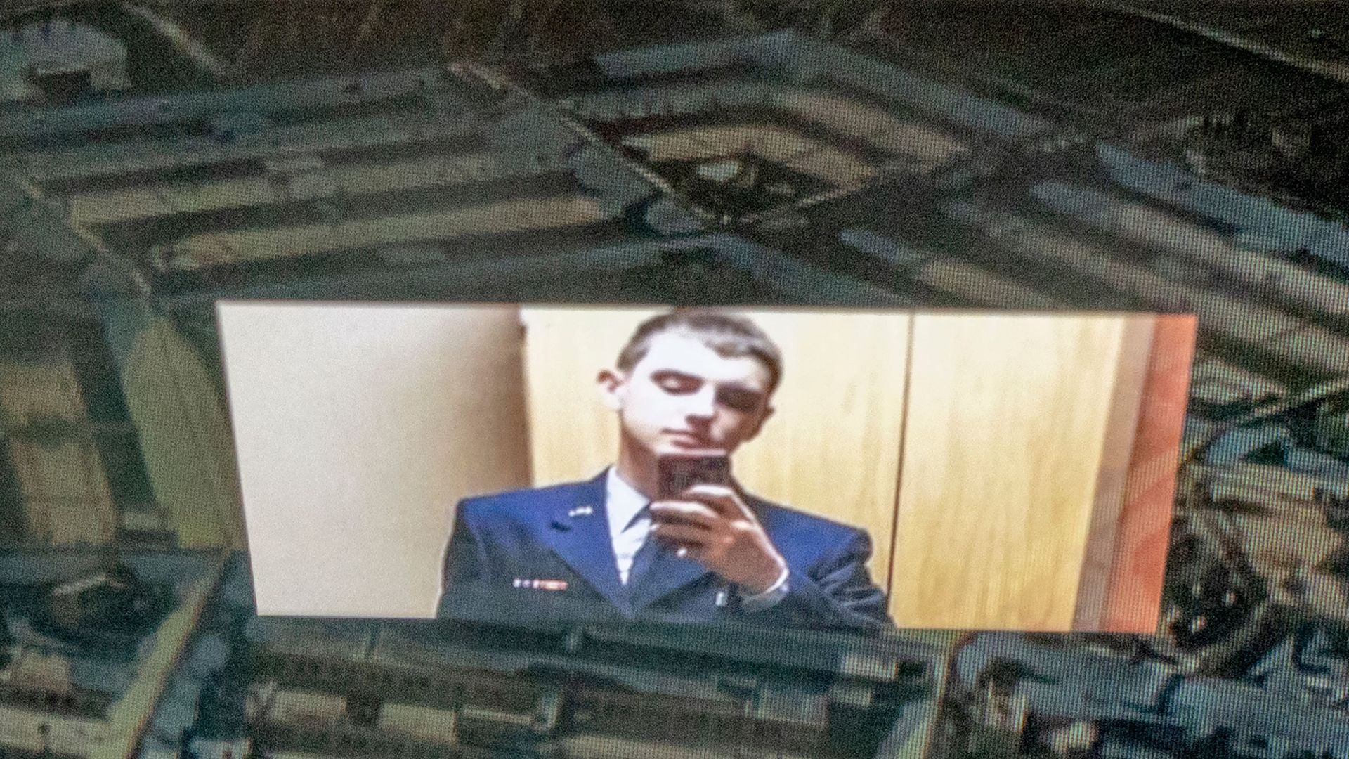 A photo of Jack Teixeira reflected on an image of the Pentagon building