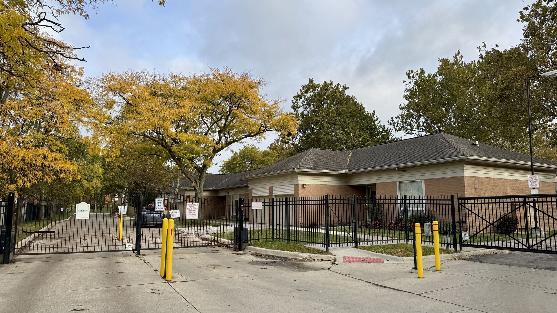 A gated brick condo development with a wide concrete street. 
