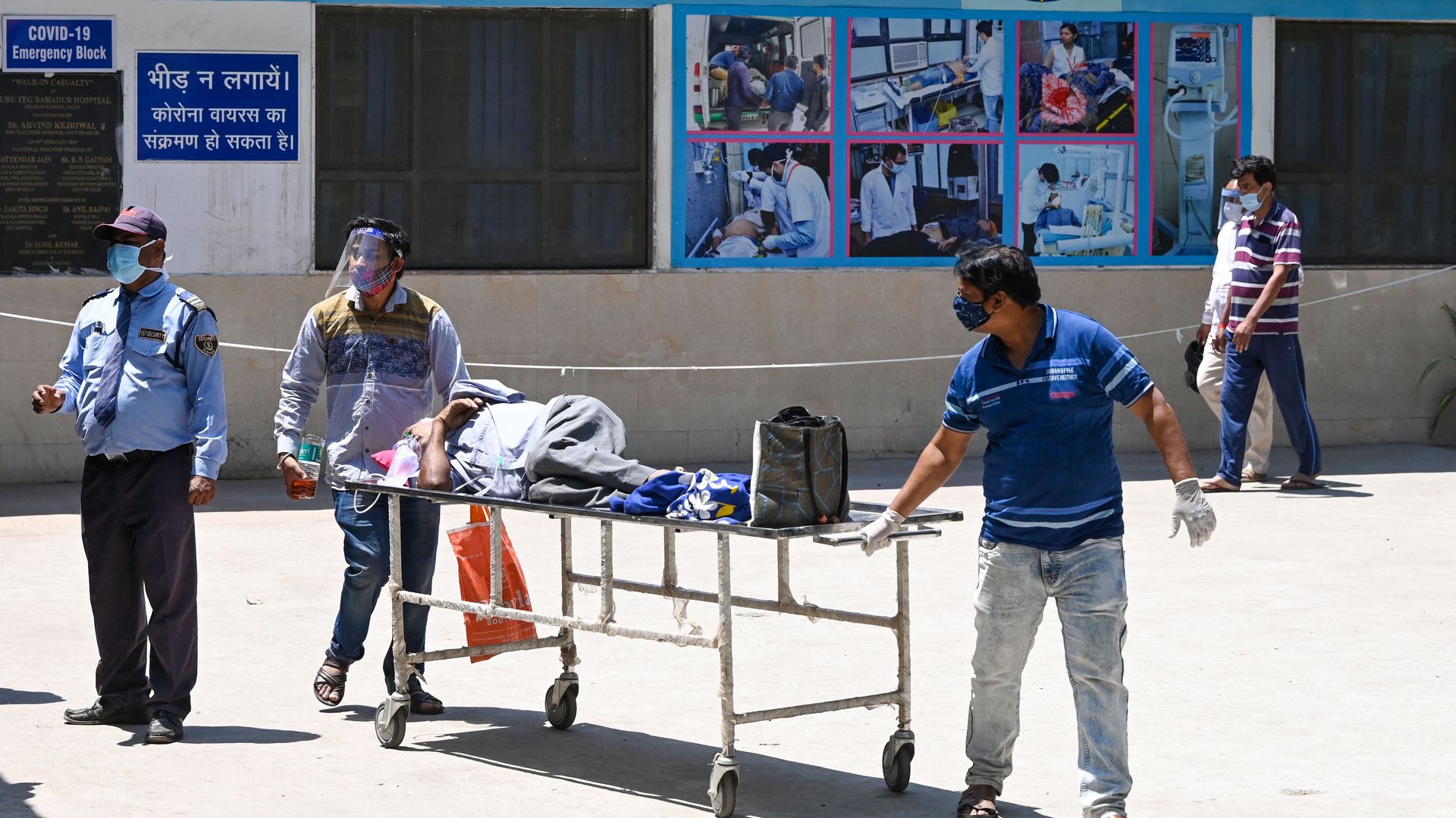 Relatives transport a Covid-19 coronavirus patient on a stretcher as they leave a hospital in New Delhi on April 24