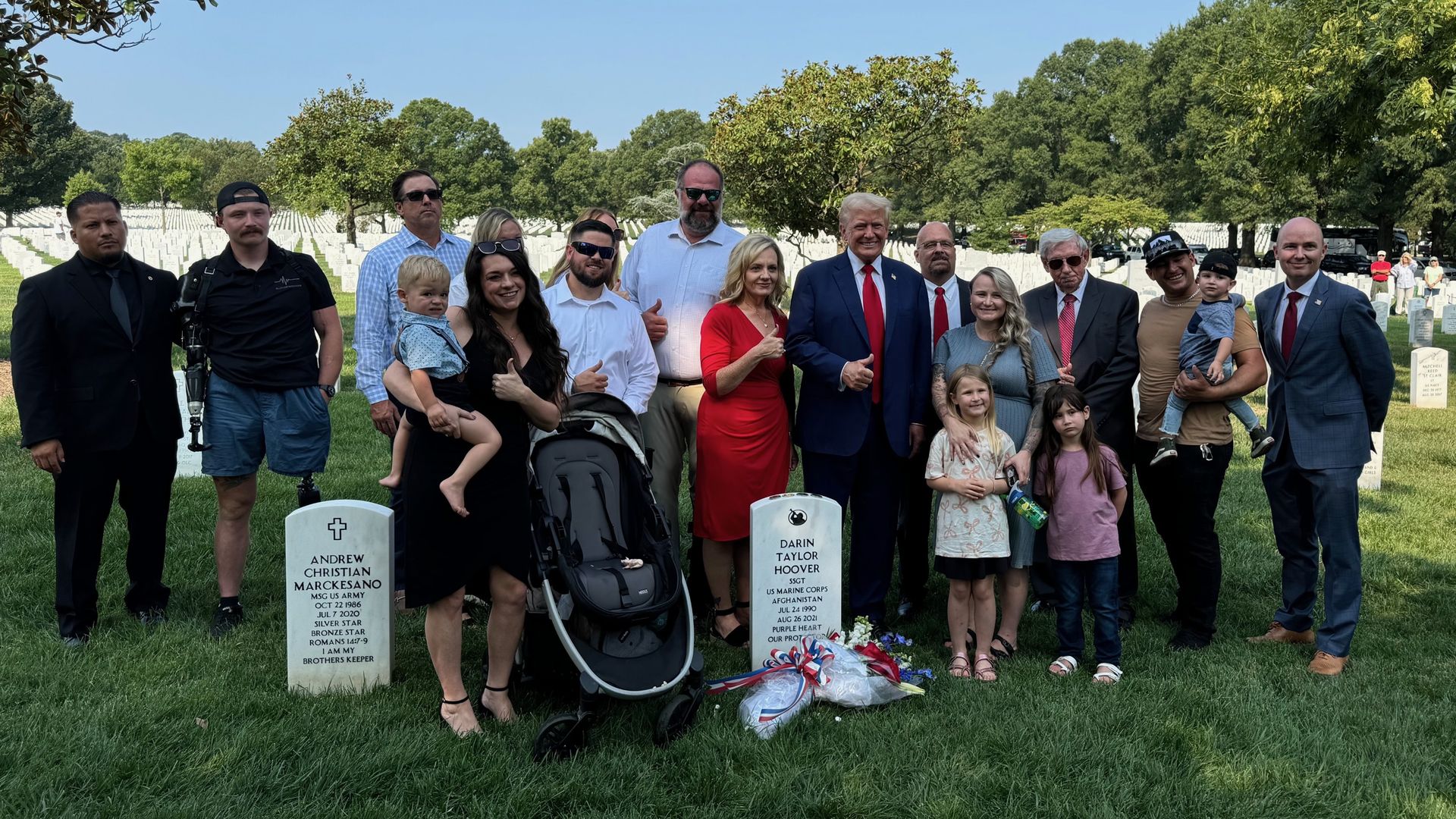 A group of people, including former President Trump and Utah Gov. Spencer Cox, standing around gravestones at Arlington National Cemetery.