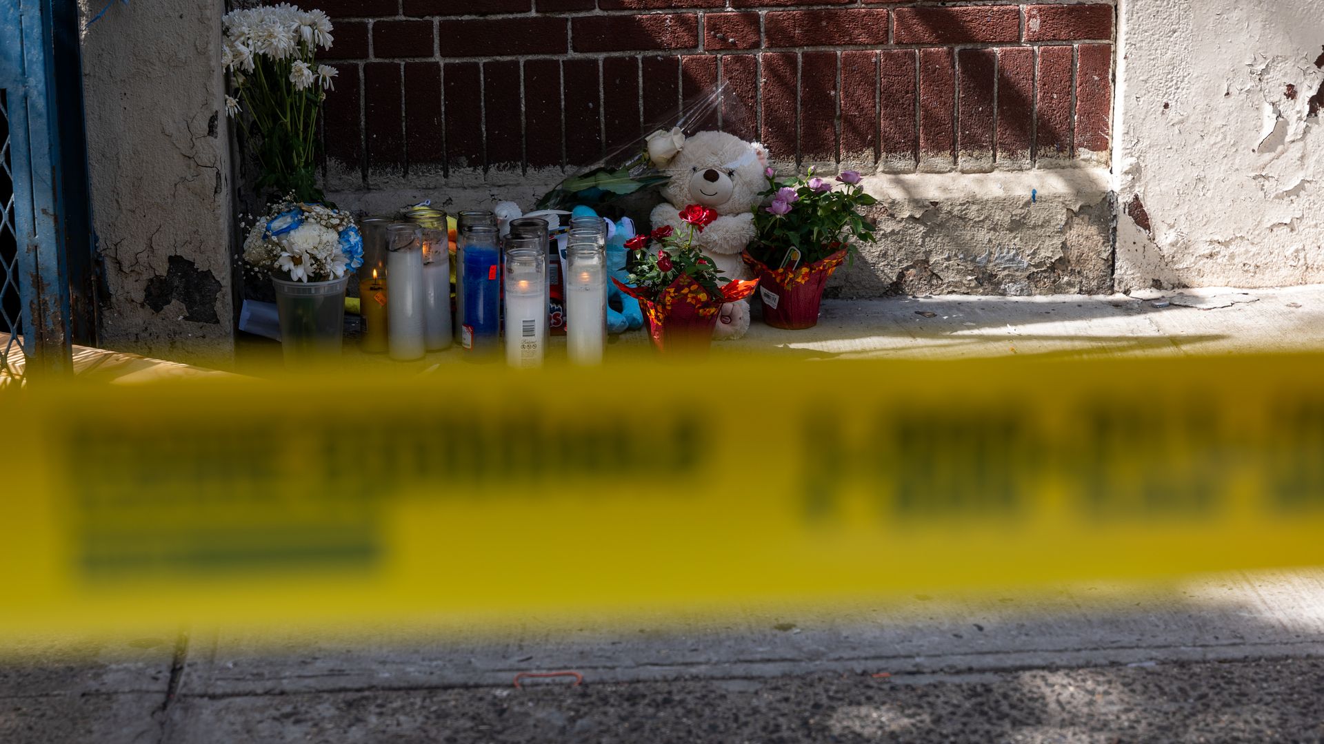 A photo of a makeshift memorial with policy tape in the foreground.