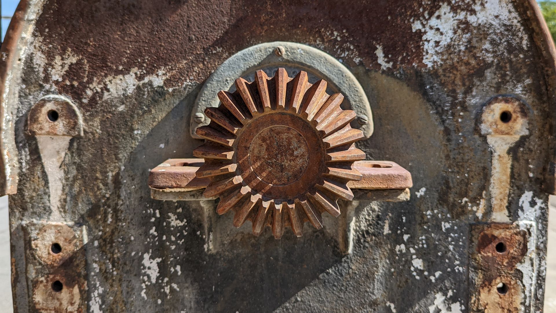 A rusty dial on a metal panel on an old machine.