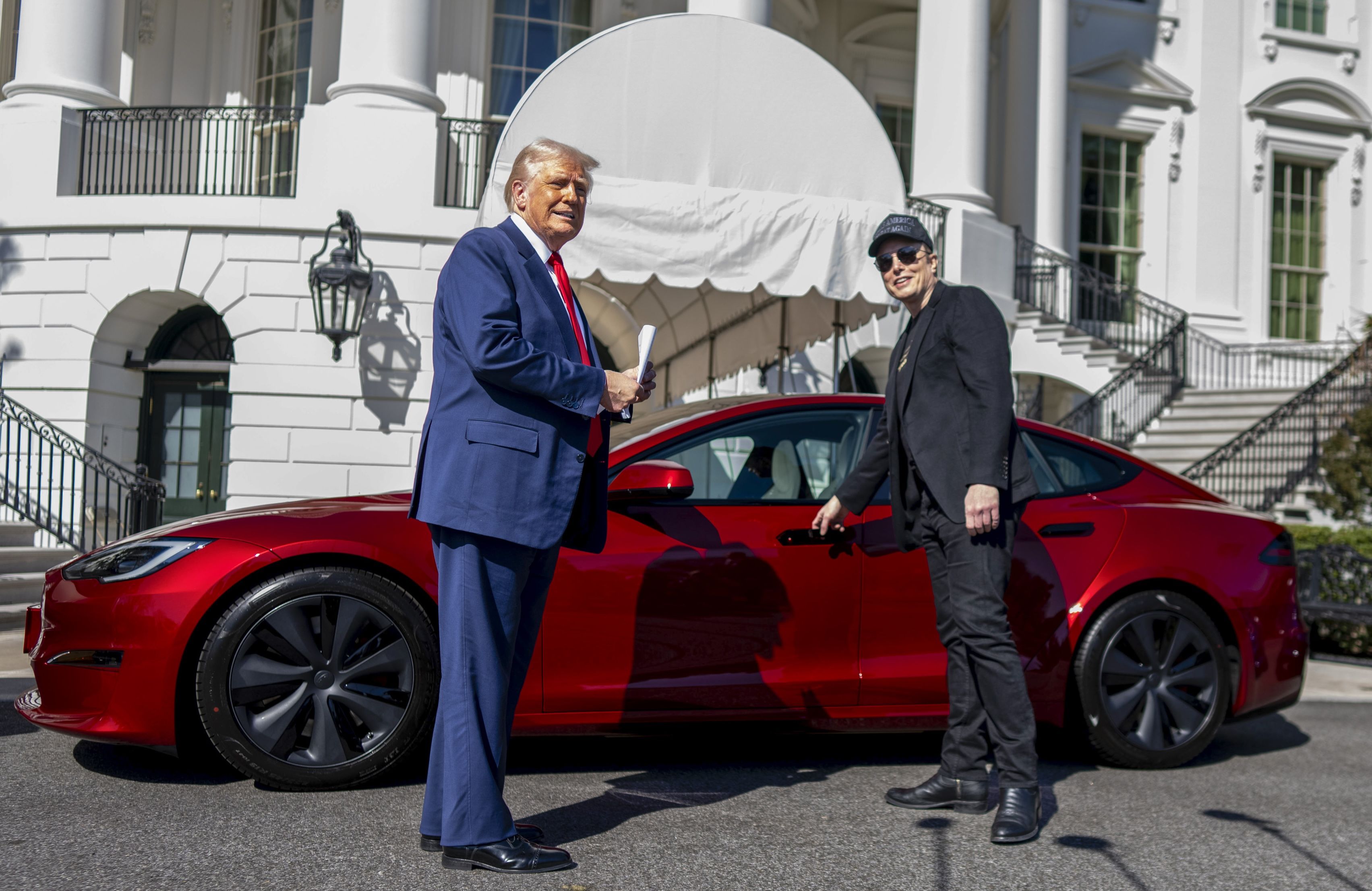 President Trump and Elon Musk look at Tesla models on the South Lawn on Tuesday.