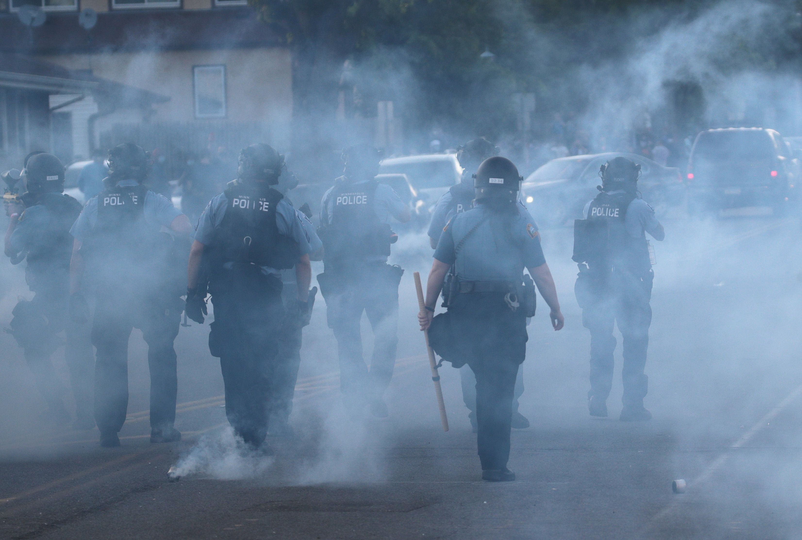 Police walking through tear gas