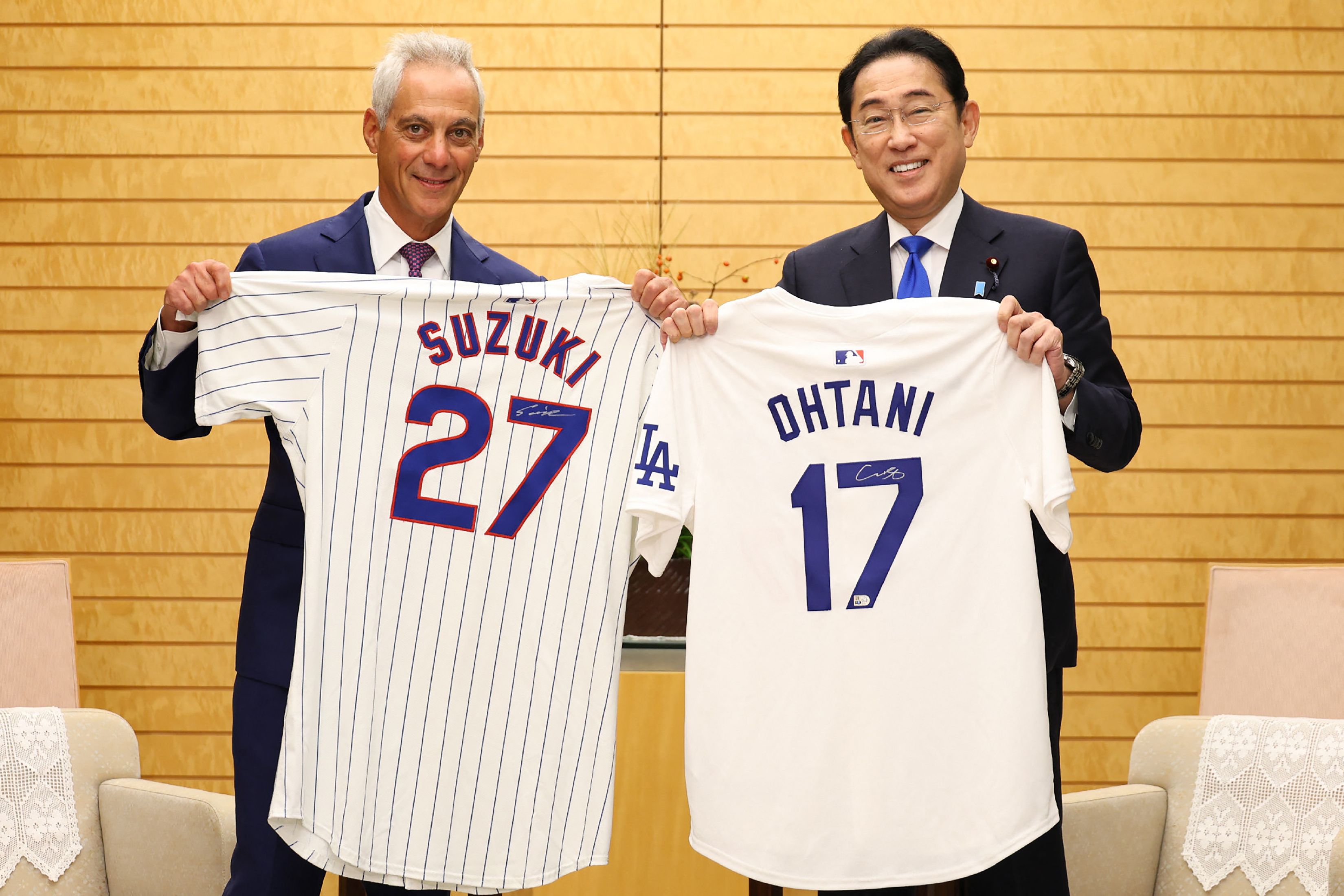 Japan's Prime Minister Fumio Kishida (R) is presented with jerseys signed by Major League Baseball (MLB) Japanese players Shohei Ohtani of the Los Angeles Dodgers and Seiya Suzuki of the Chicago Cubs from US ambassador to Japan Rahm Emanuel (L) during their meeting at the prime minister's office in 