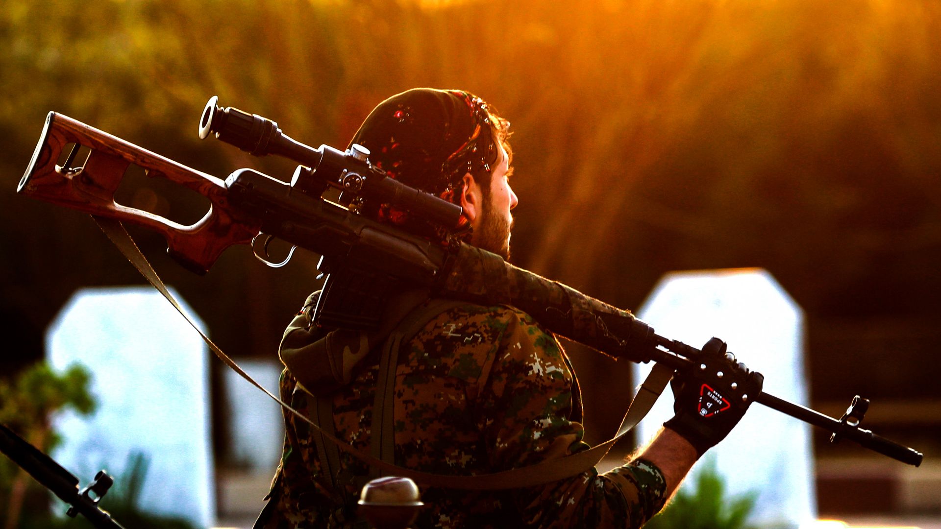 A Syrian Democratic Forces'(SDF) fighter holds a sniper rifle on his shoulder as he attends the funeral of a slain Kurdish commander in the northeastern city of Qamishli on December 6, 2018.