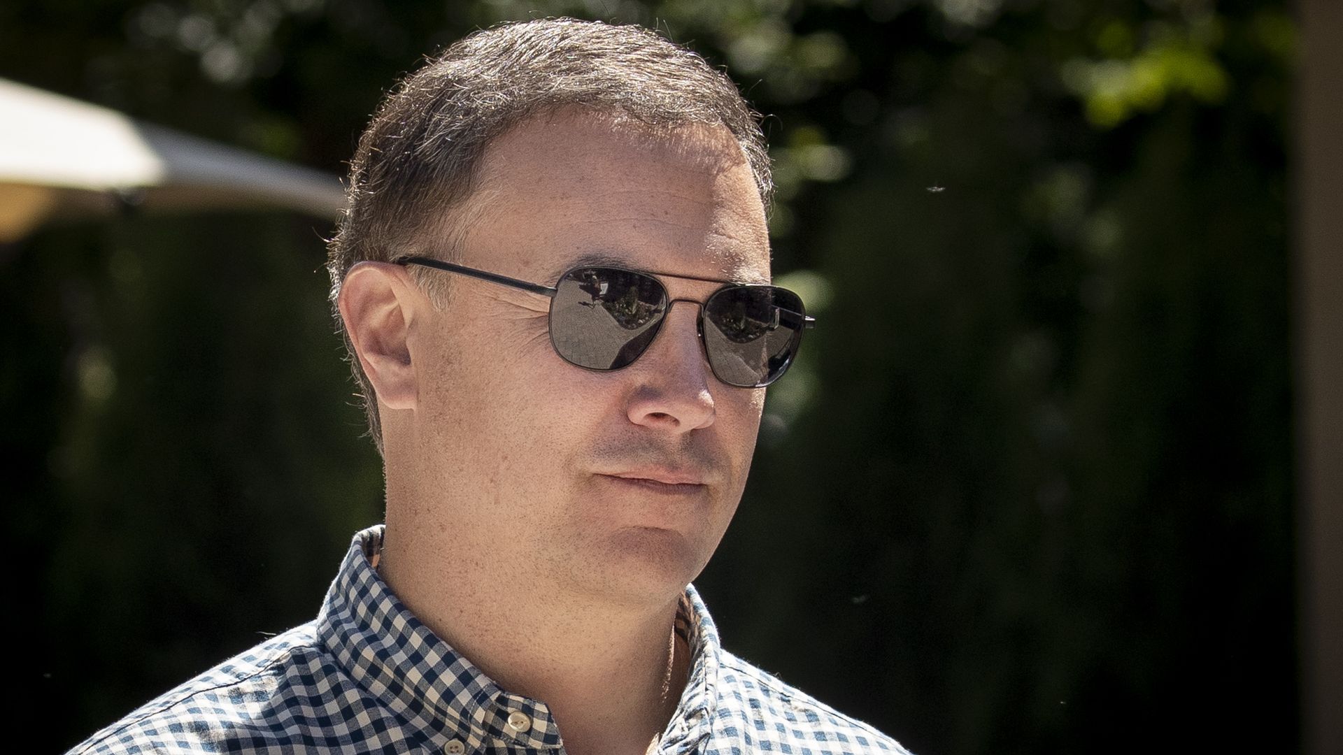 Jim Lanzone wearing aviator sunglasses and a checkered collared shirt 