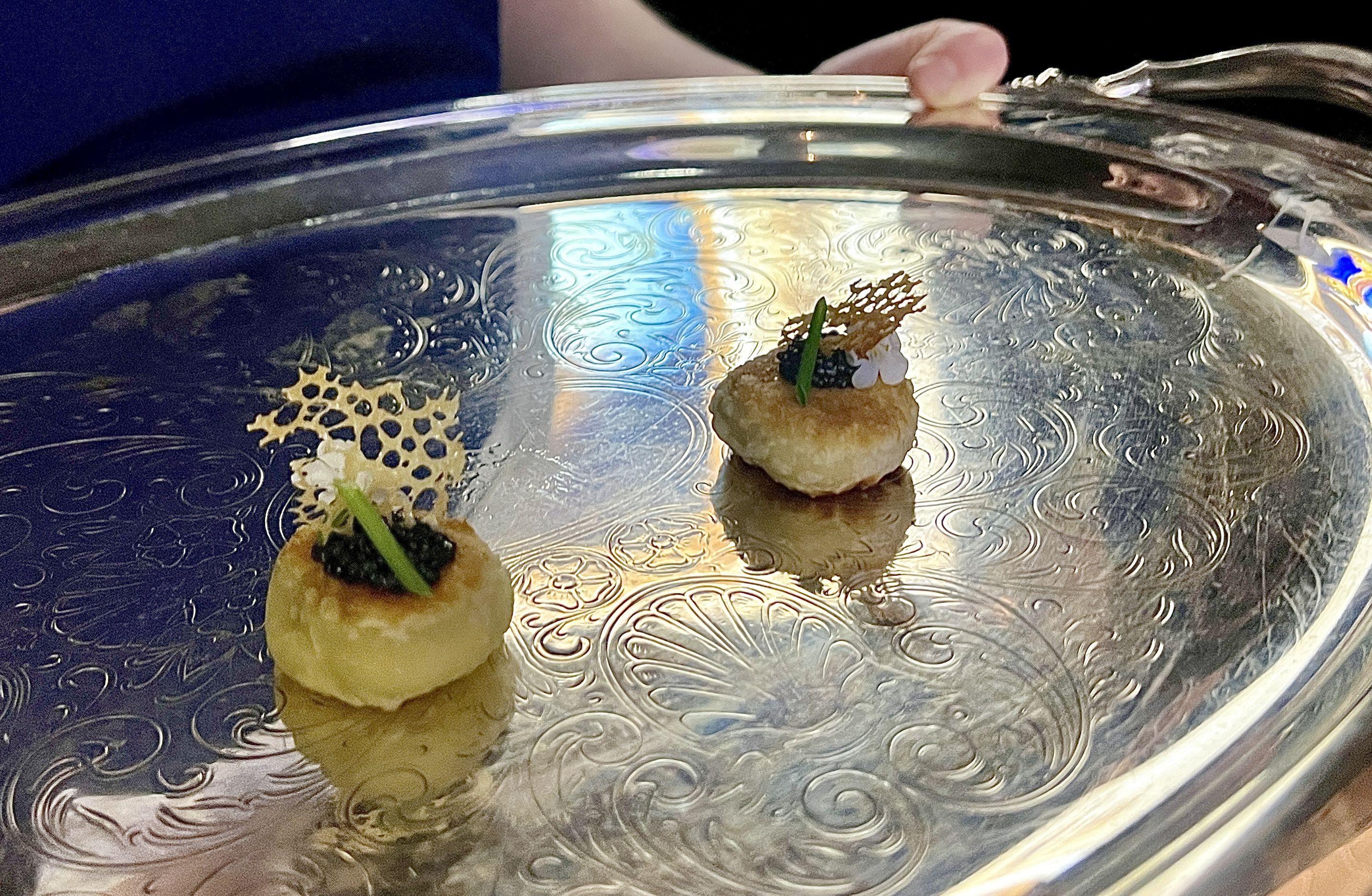 two small bites of food with caviar on top