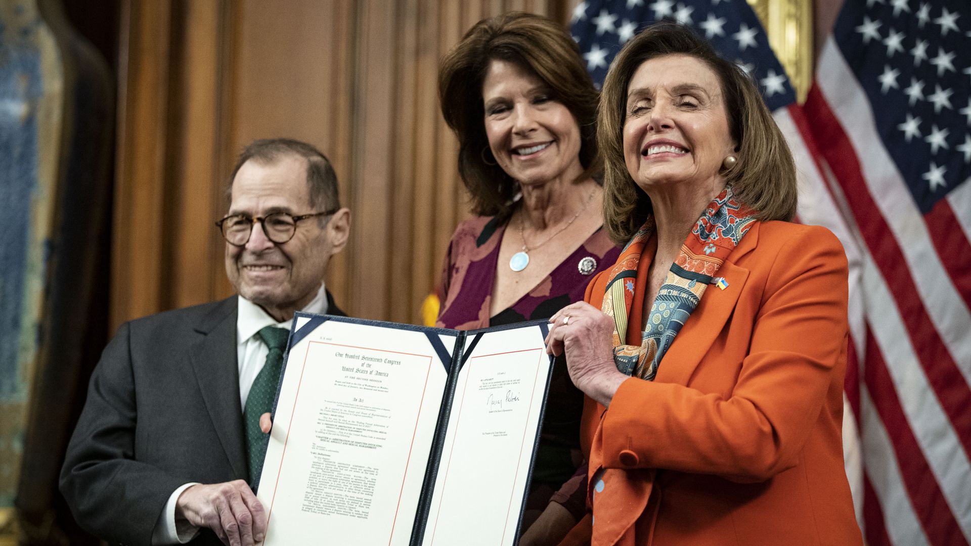 House Speaker Nancy Pelosi is seen smiling with other lawmakers after moving a law banning forced arbitration in sexual harassment cases.