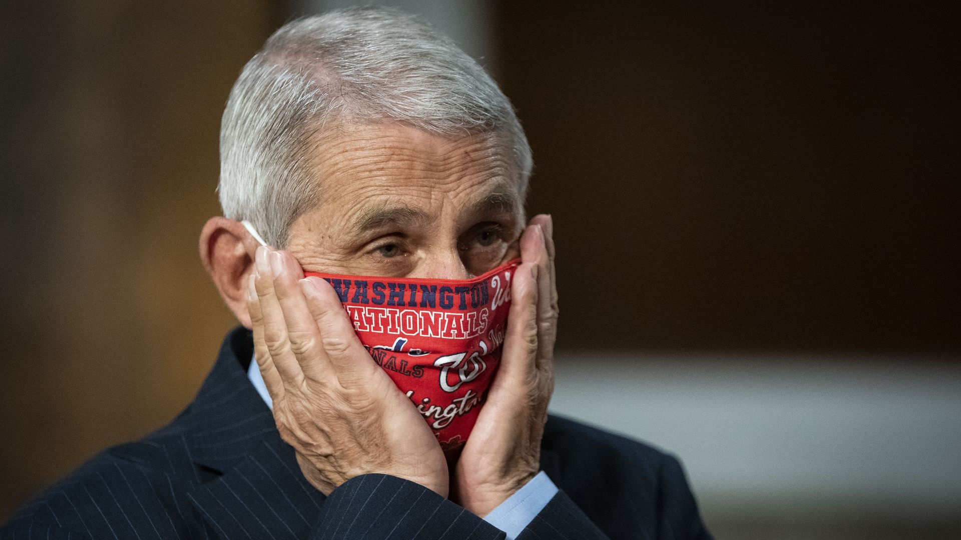 Anthony Fauci, director of the National Institute of Allergy and Infectious Diseases, adjusts a Washington Nationals protective mask while arriving to a Senate hearing in June