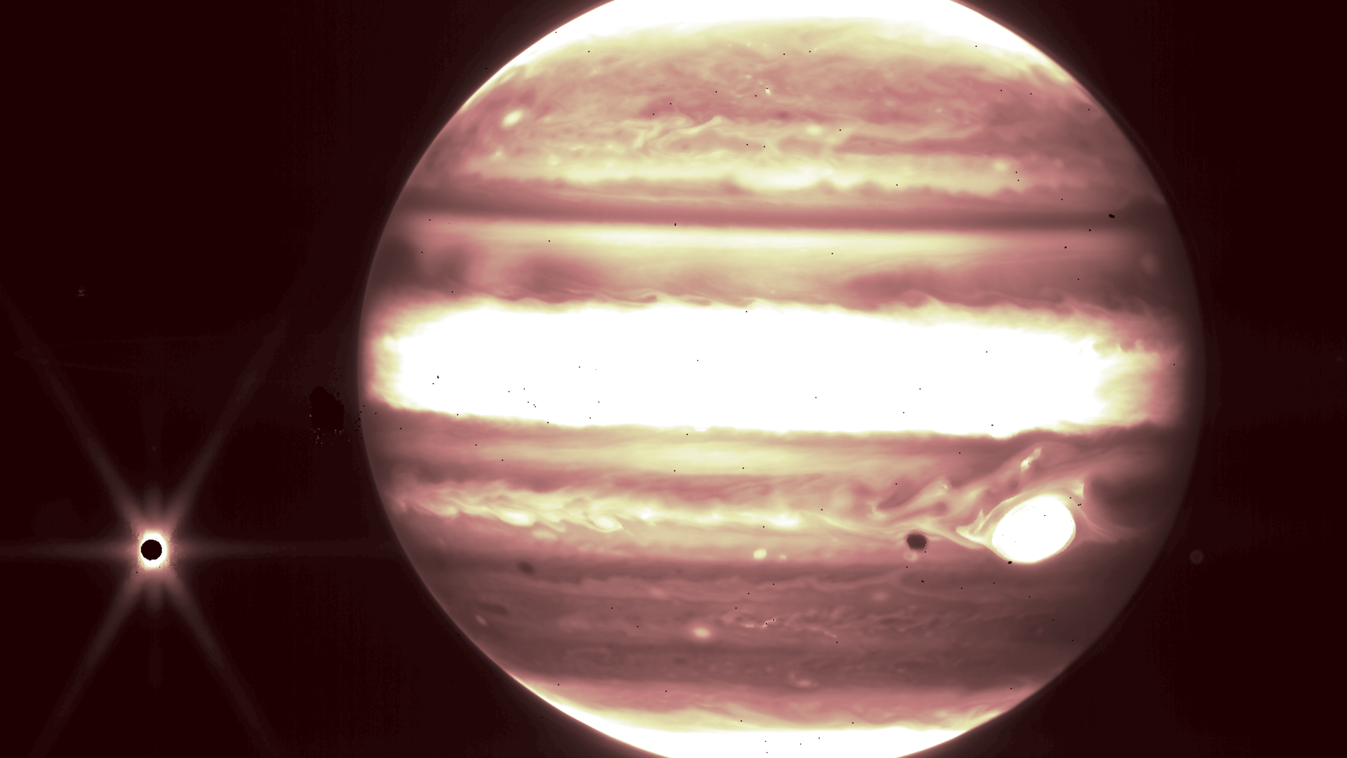 Jupiter shining in red and yellow seen in infrared by the James Webb Space Telescope.