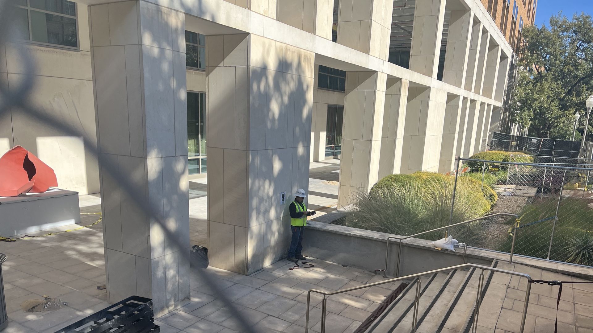 The sculpture can be seen to the left, with a construction worker on site.