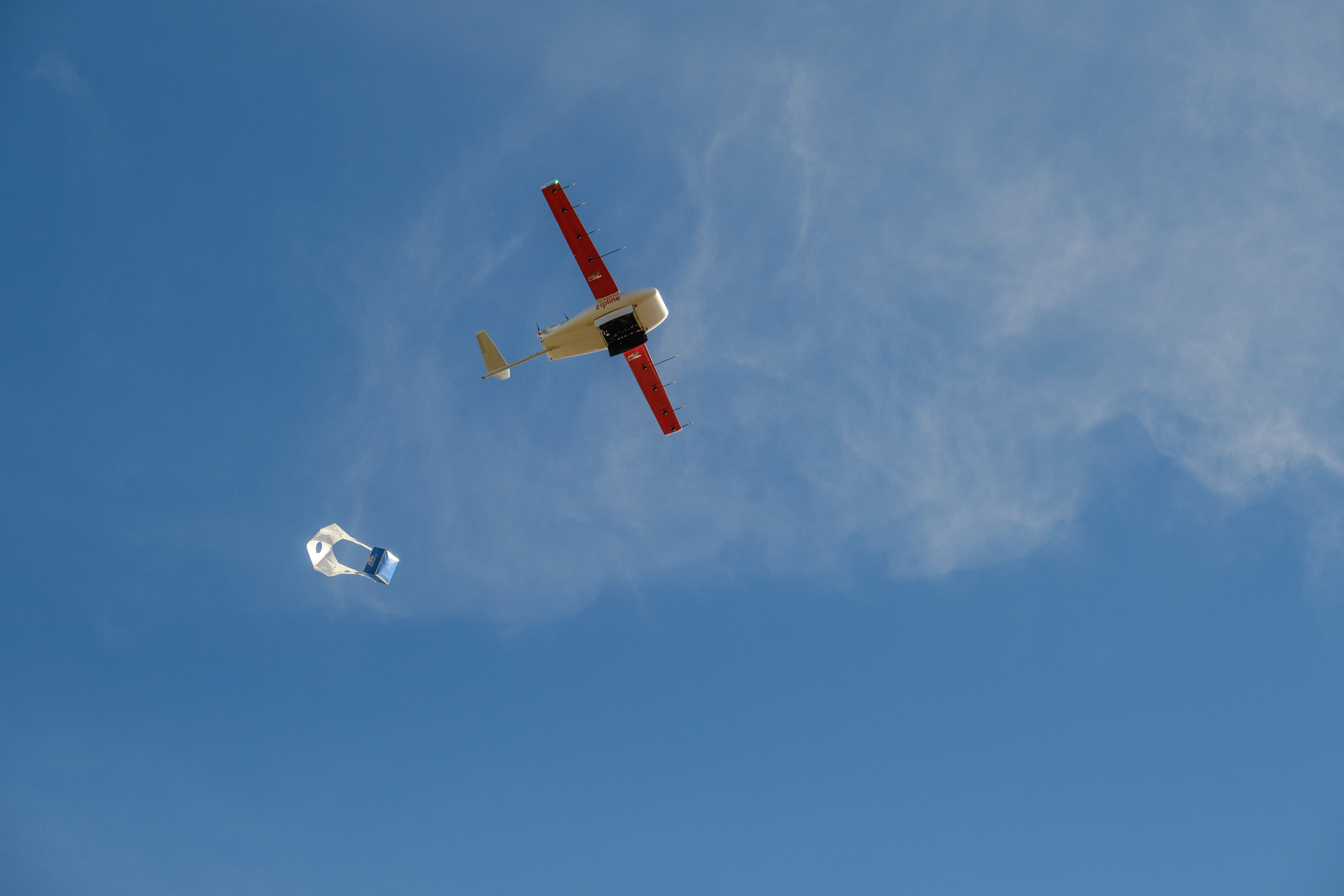 A Zipline drone drops a package. 