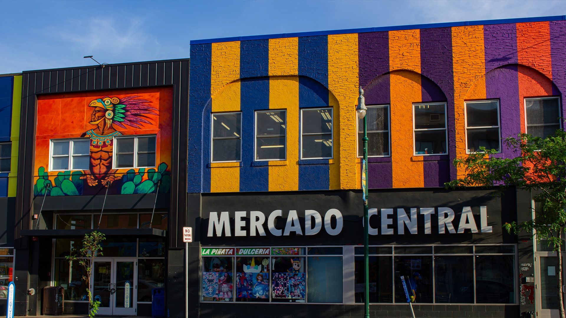 Colorful exterior of Mercado Central in Minneapolis, featuring a vibrant mural and a storefront window display.