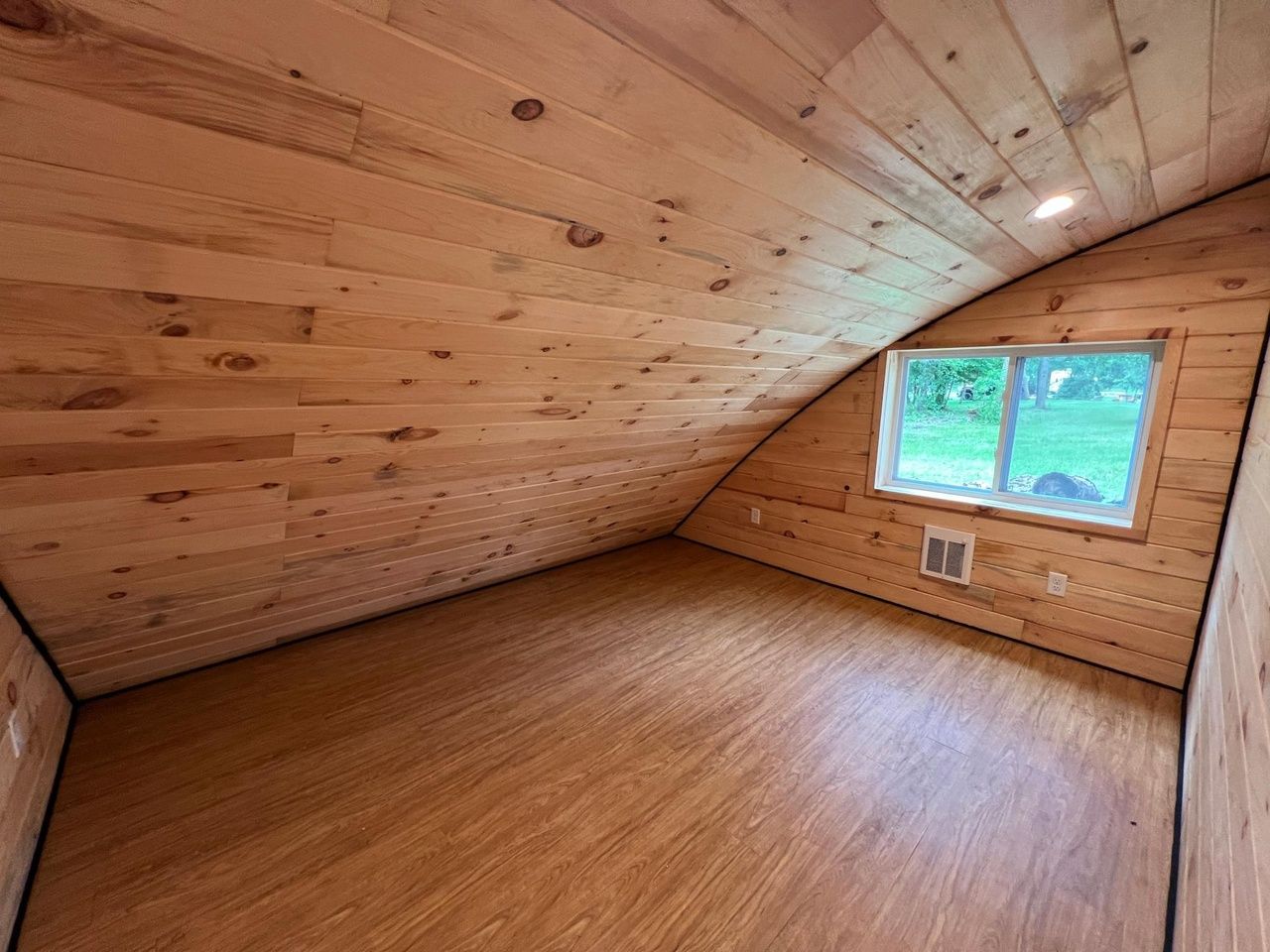 A bedroom with a sloped ceiling.
