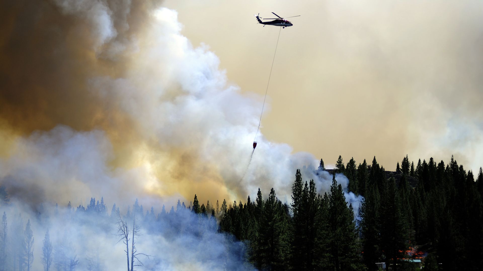 A helicopter dropping water on the Sugar Fire near Doyle, California, on July 12.