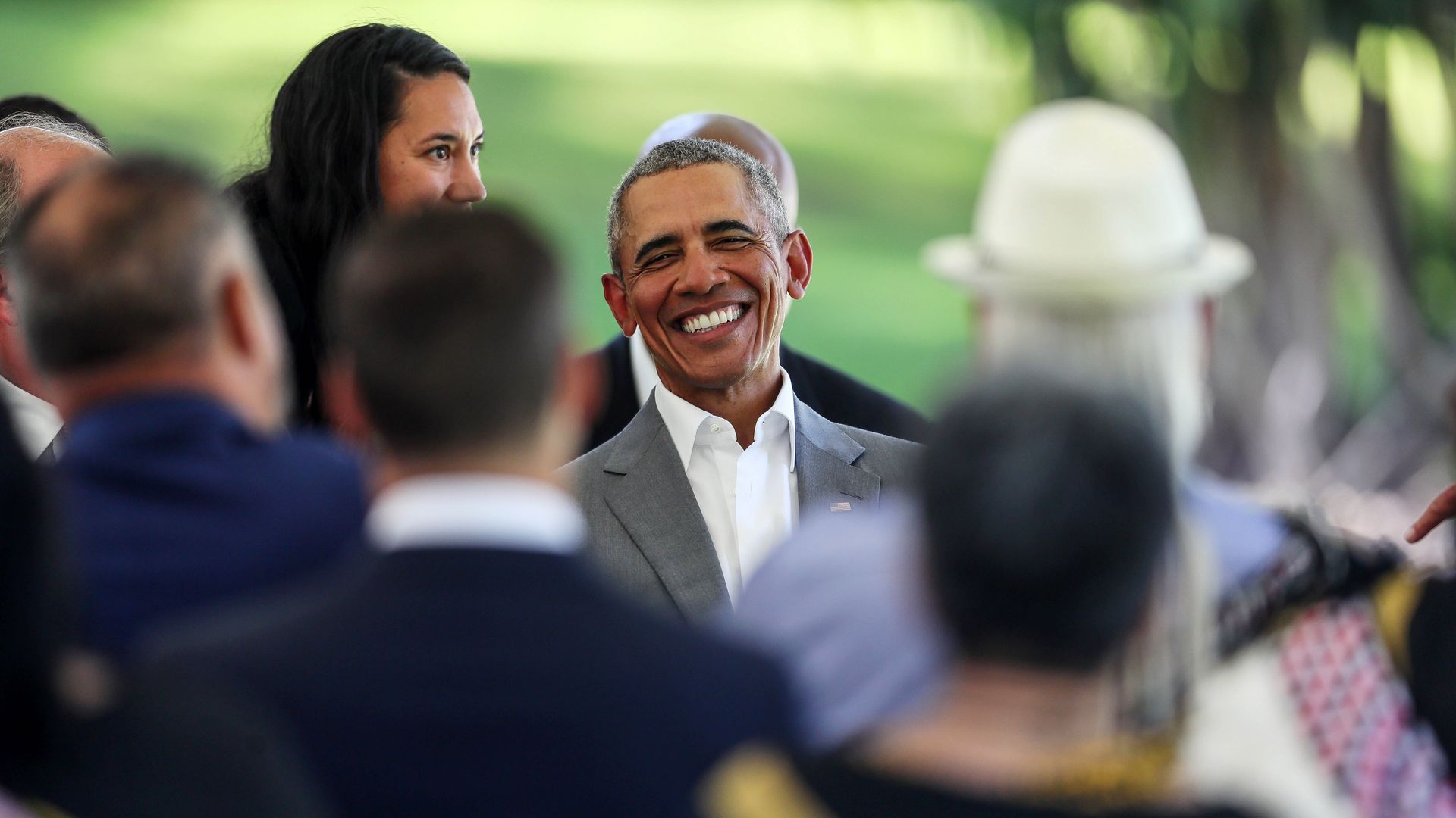 Former president Barack Obama smiling in a crowd.