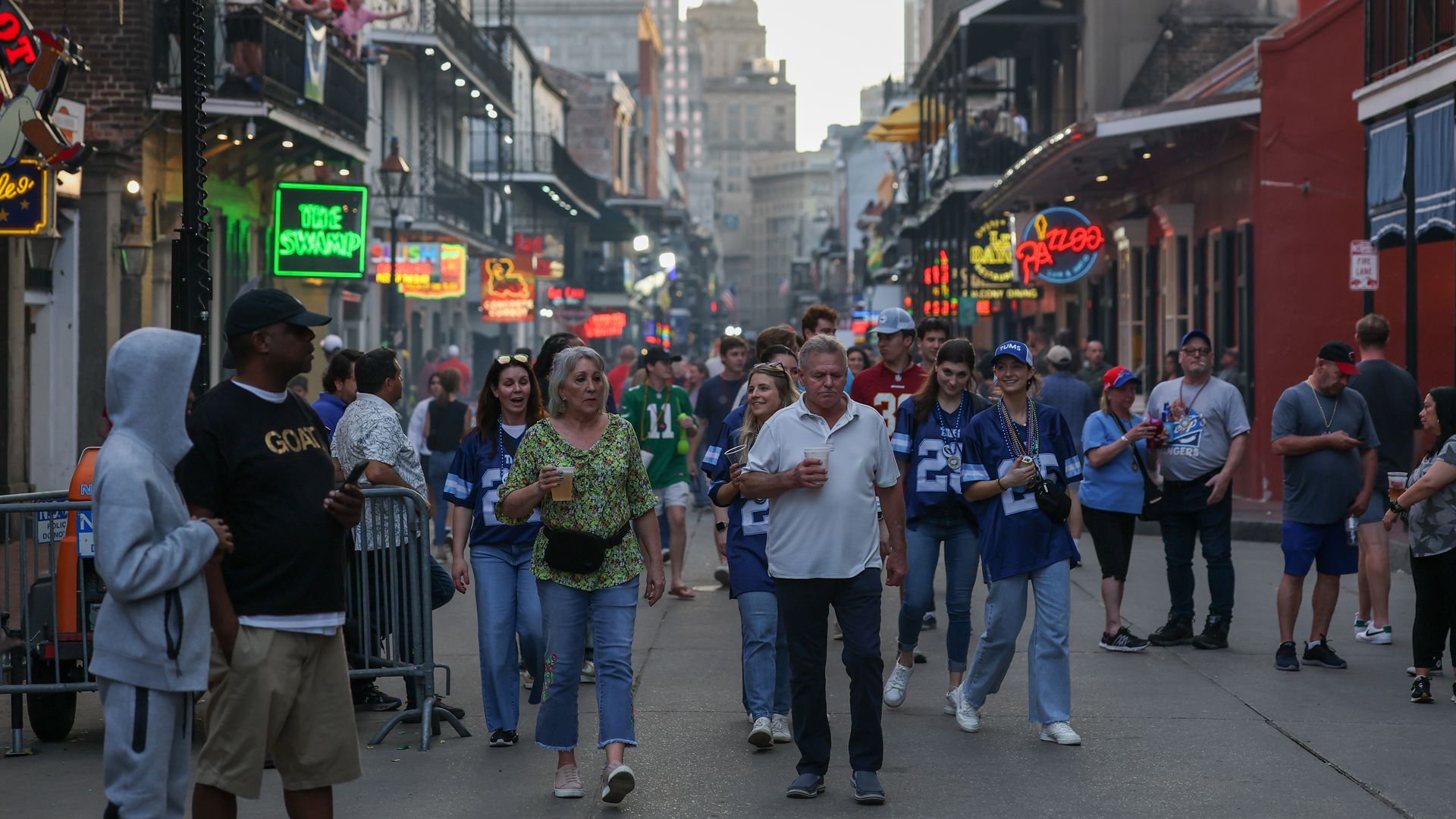 Photo shows people walking on Bourbon Street.