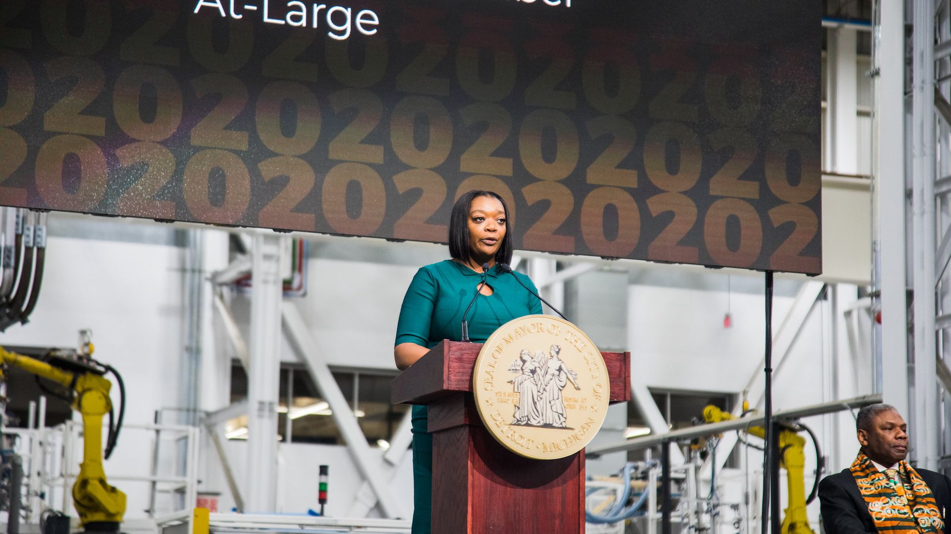 Janeé Ayers stands speaking at a lectern.
