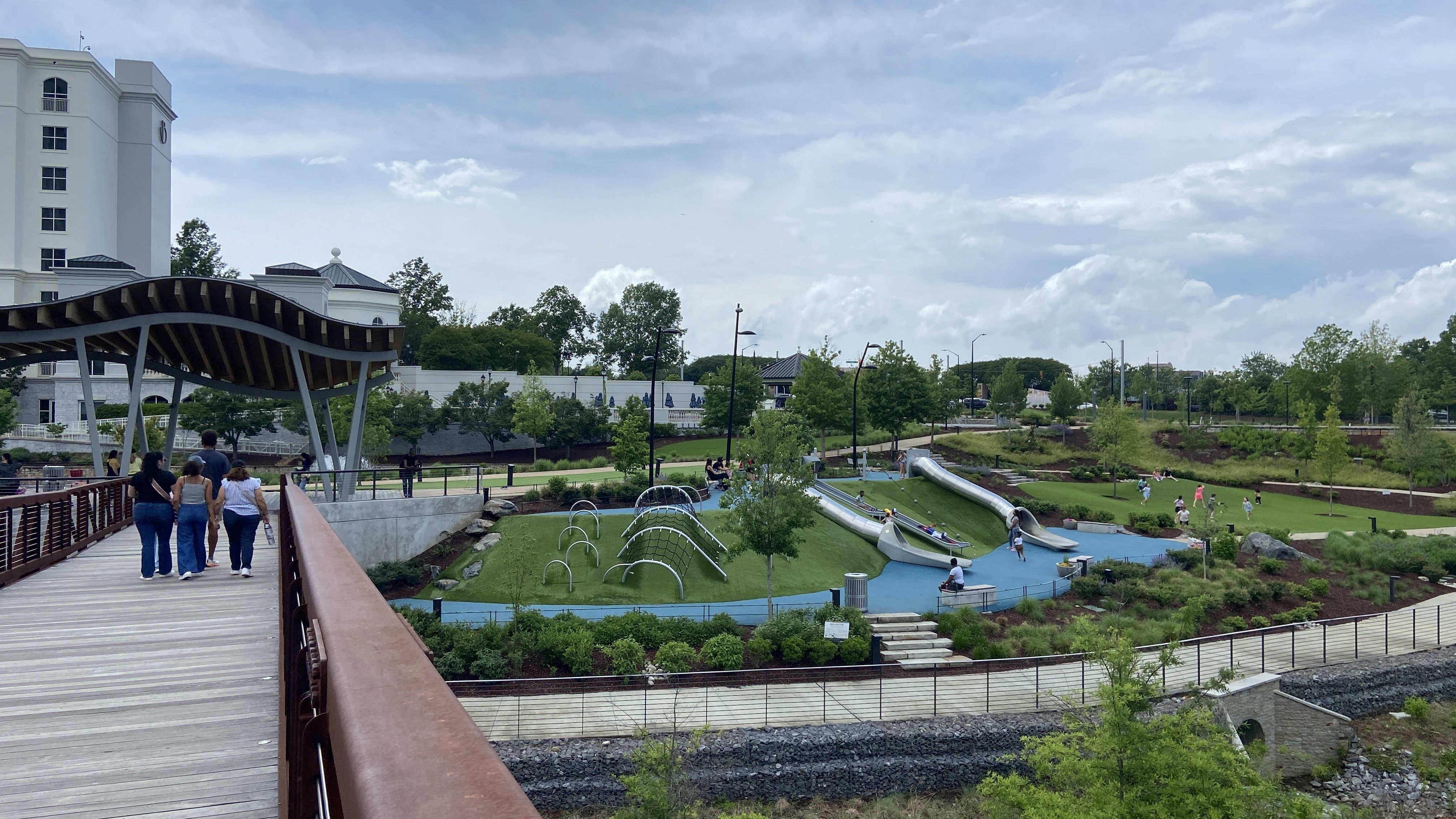A pedestrian bridge in front of the Ballantyne hotel with a playground to the right. 