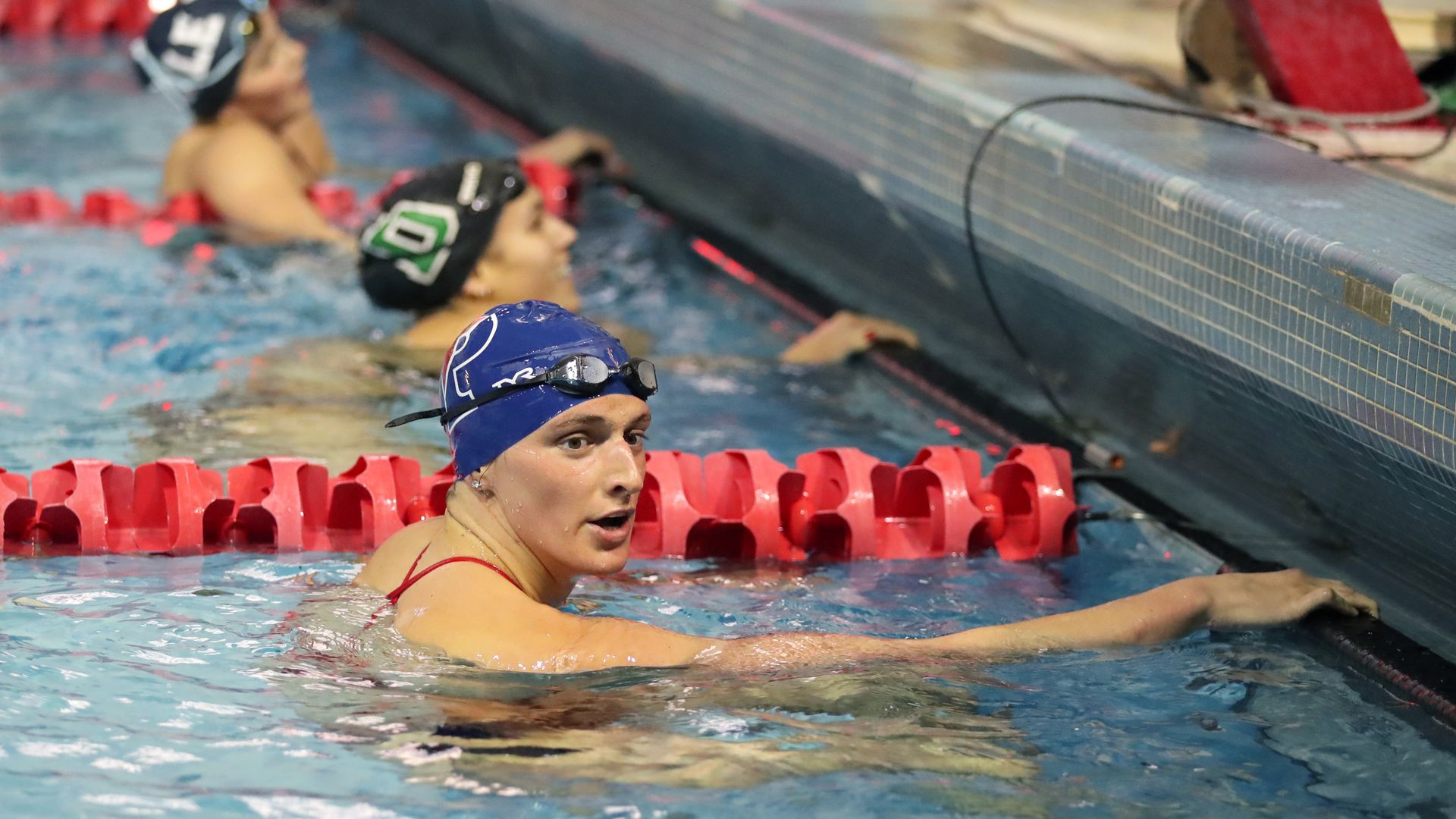 Photo of Lia Thomas in a swimming pool lane with competitors in the lanes next to her