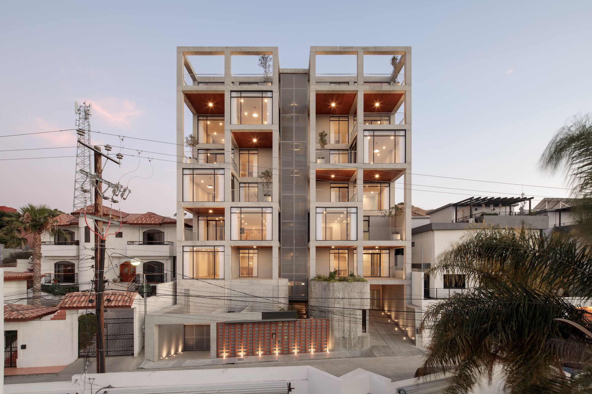 A concrete apartment building with large windows and terraces.