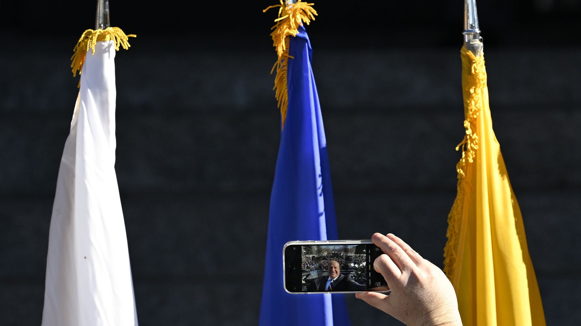 Colorado Governor Jared Polis takes a selfie before addressing the crowd during the 2023 Inauguration ceremony for his second term outside the west steps of the Colorado State Capitol .