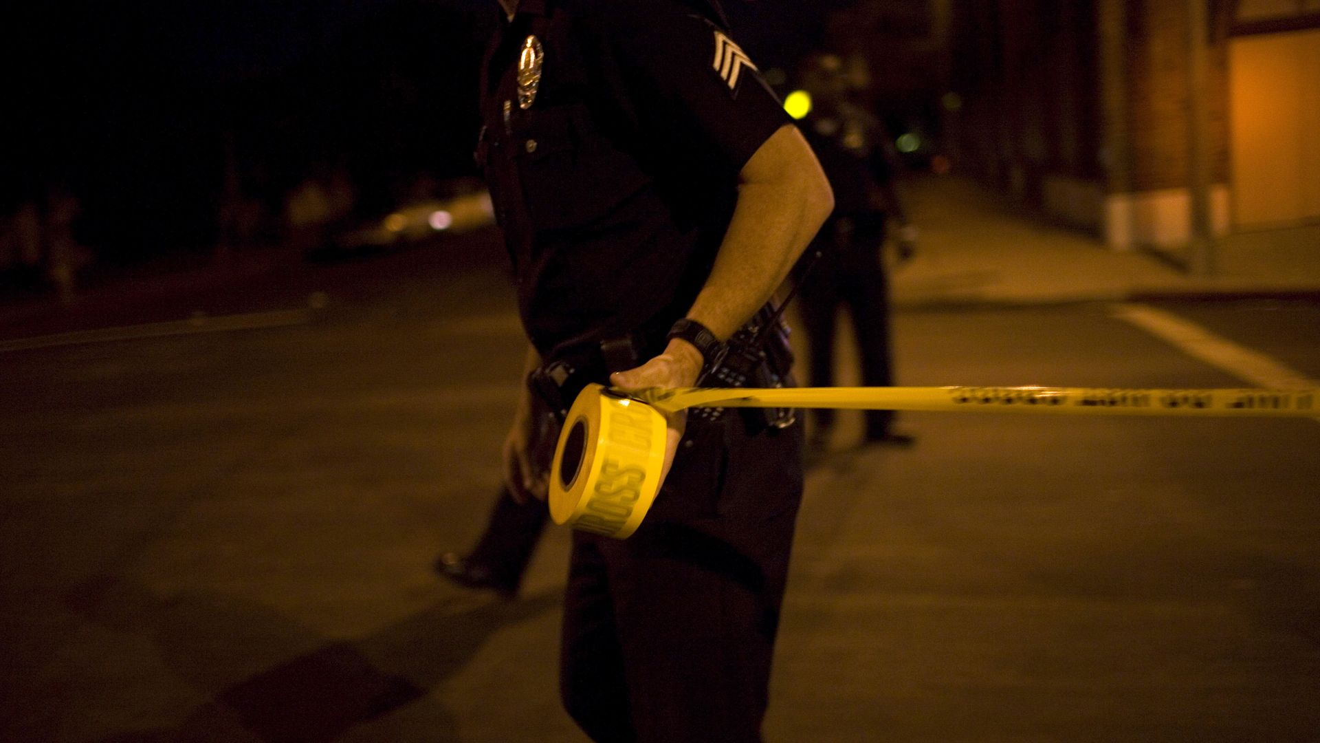 Los Angeles Police Department gang unit officers tape off a Crime Scene Investigation area following the shooting of a man September 14, 2007 in the Northeast precinct of Los Angeles, California.