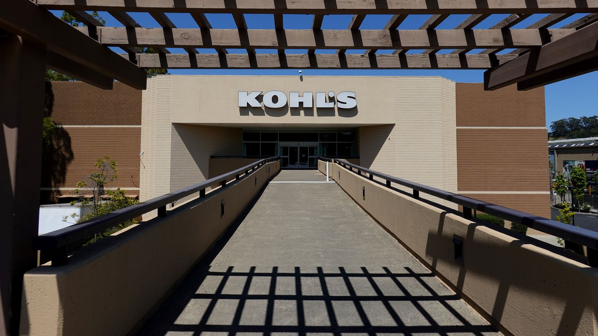 A photo of an outdoor walkway leading into a Kohl's store