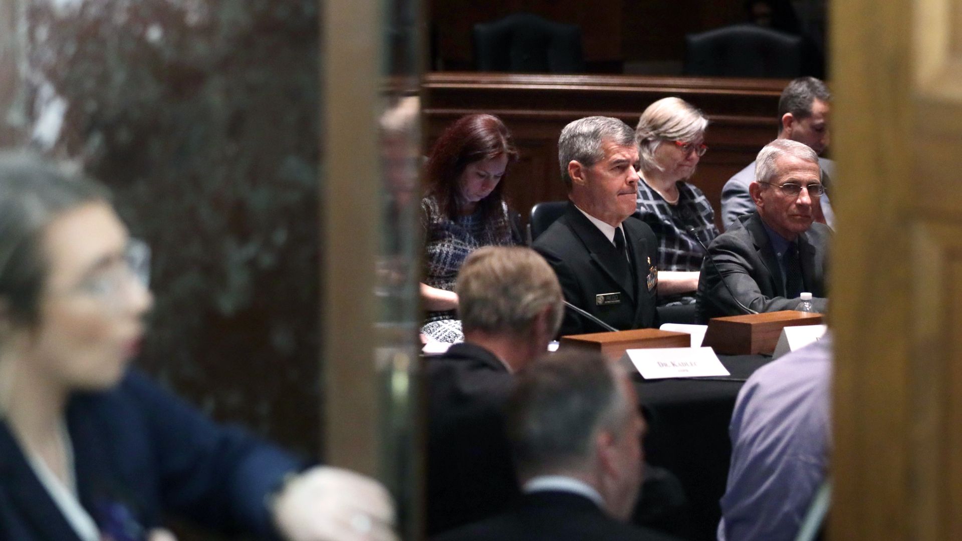 Photo of health officials sitting in a hearing with lawmakers