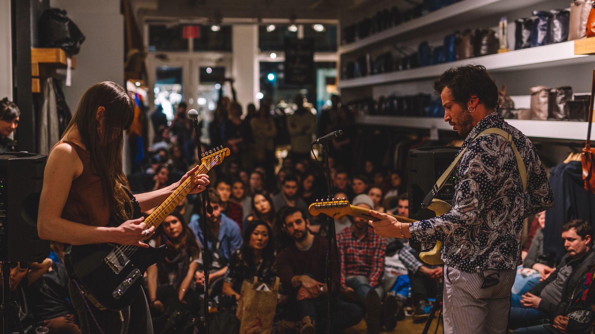 Two guitarists perform inside a sneaker store in New York City.