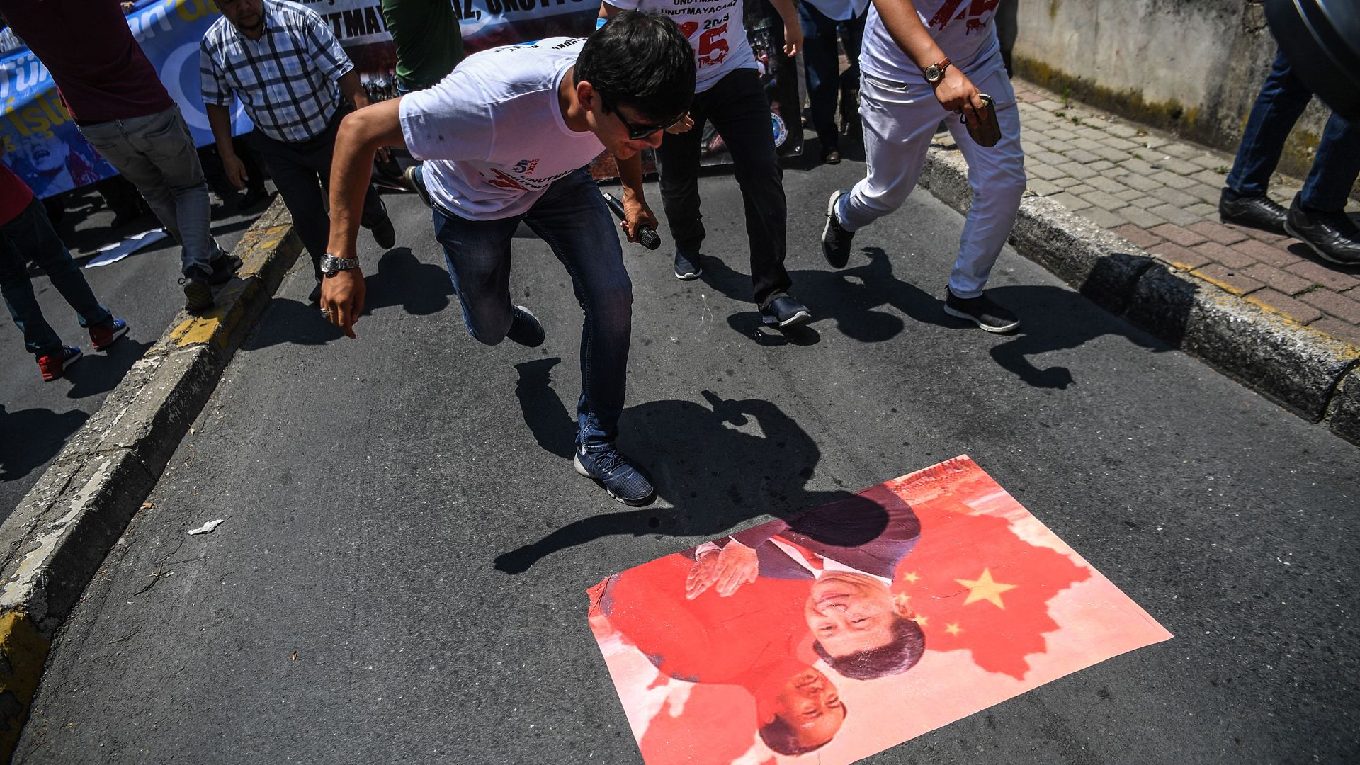People spit on a poster of Chinese President Xi Jinping. 