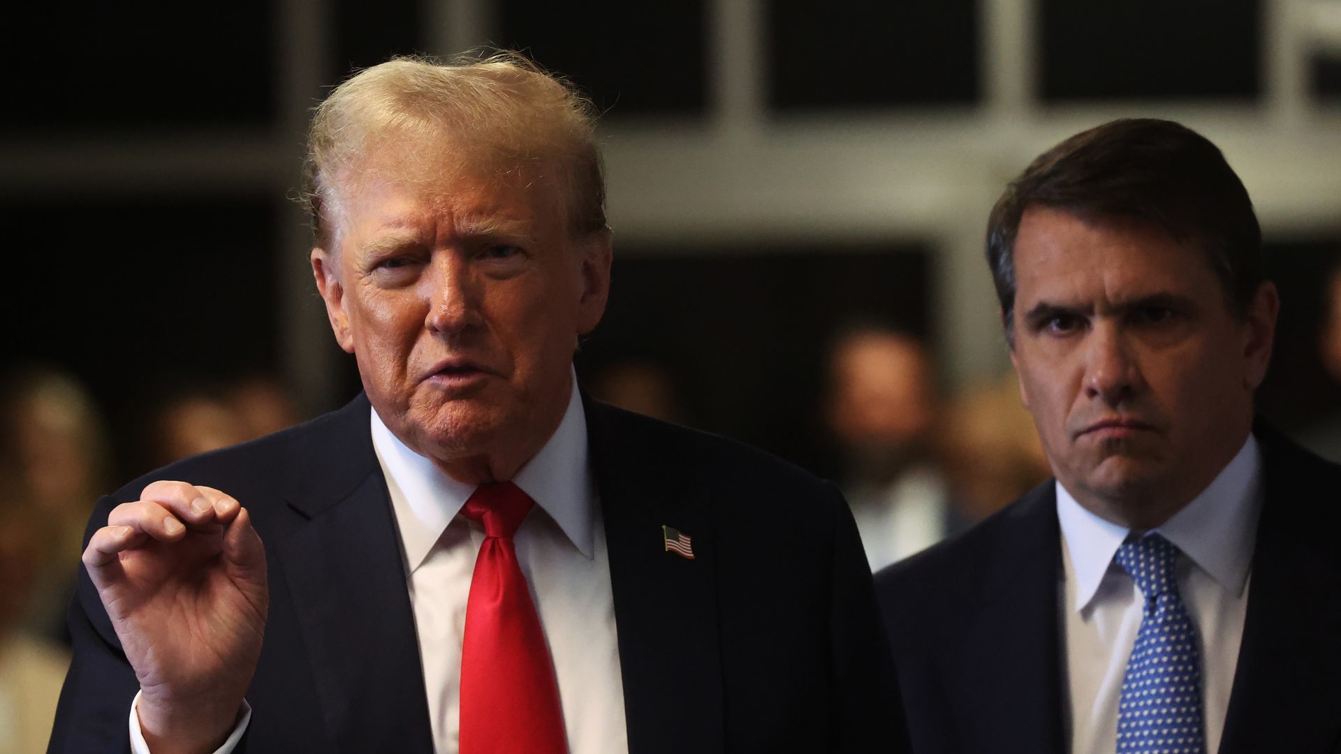 Former U.S. President Donald Trump speaks to the media with his attorney Todd Blanche (R) during his