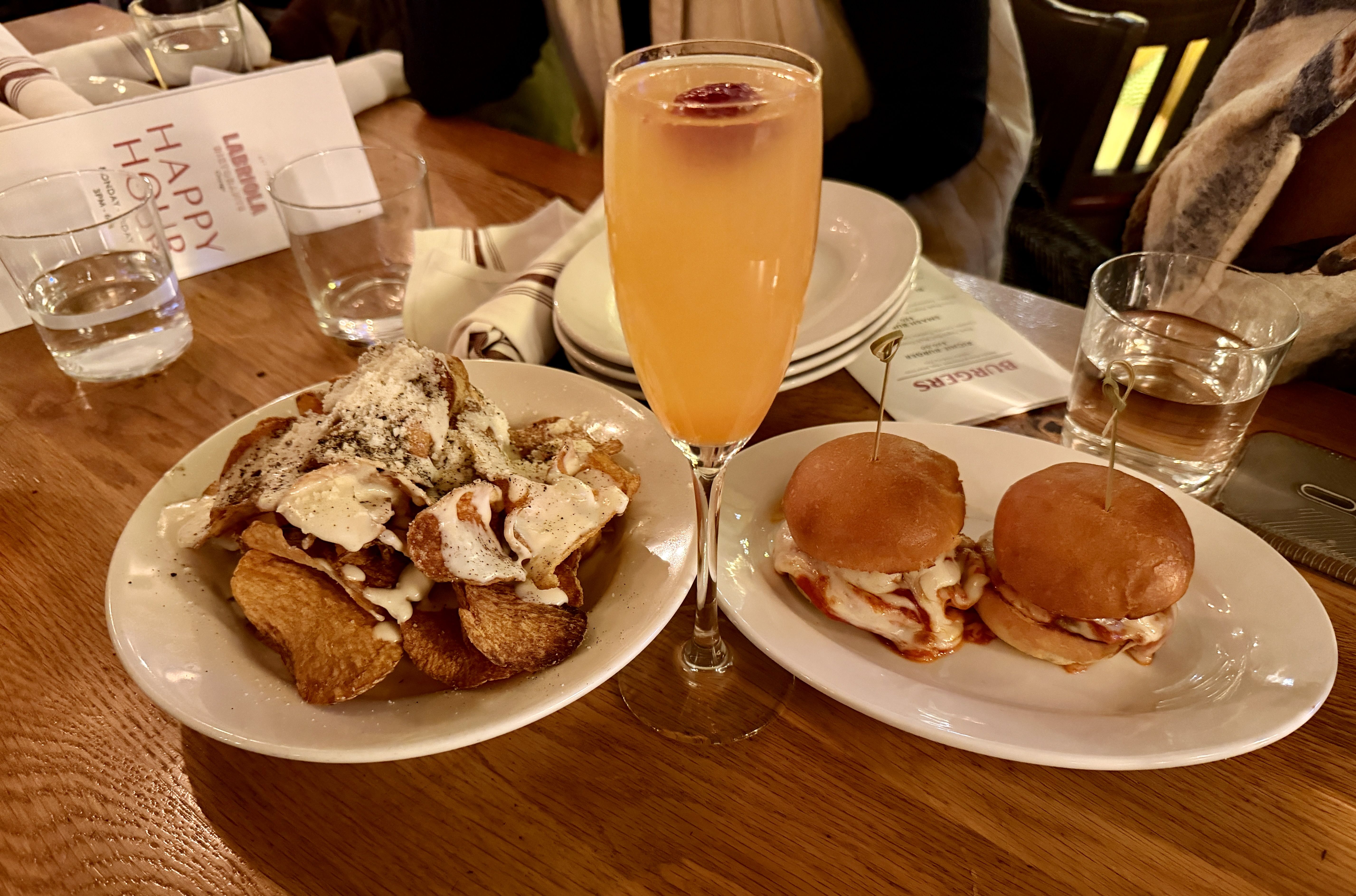 Chips, a cocktail and sliders on a table. 