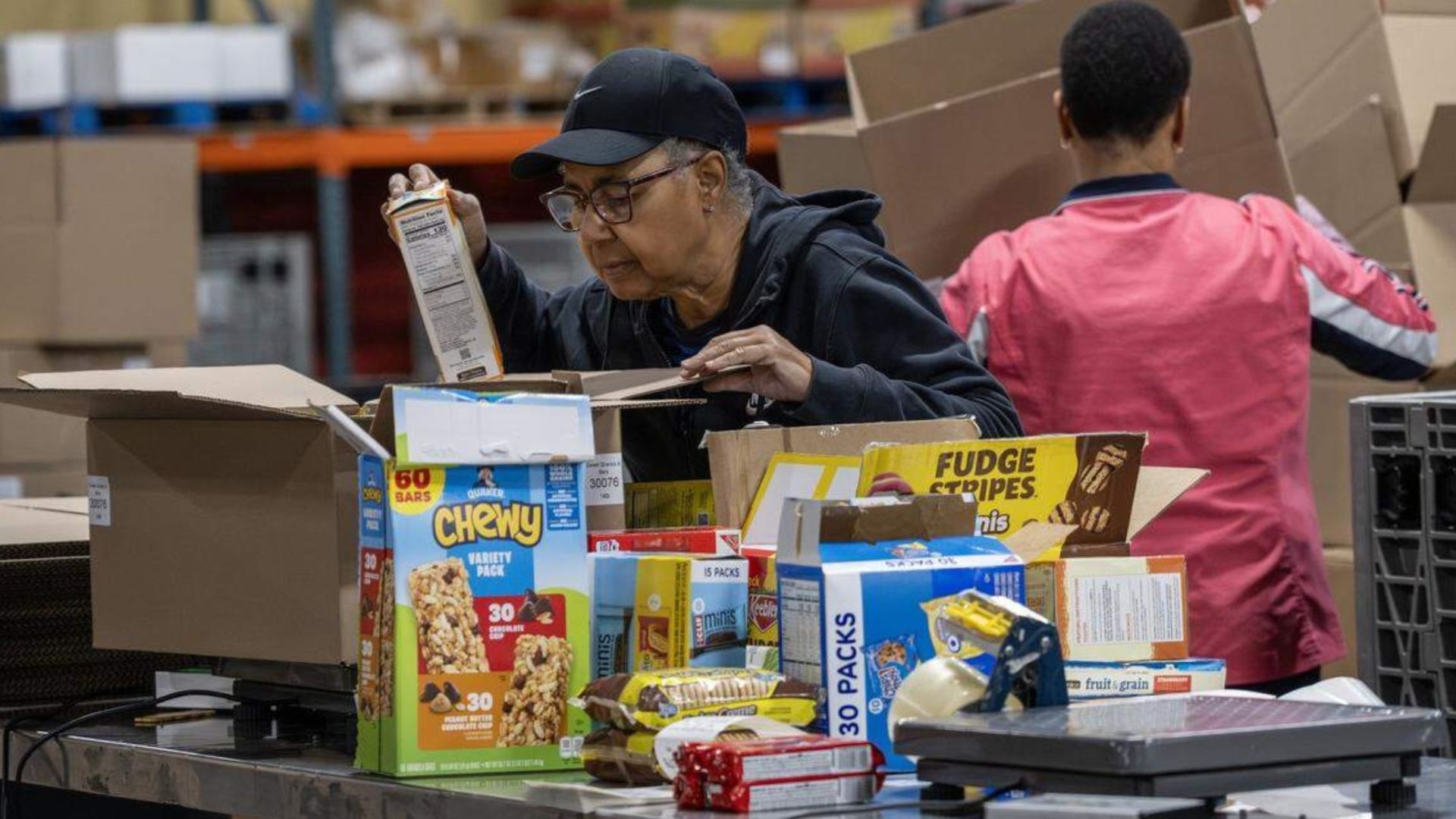 A Harvesters volunteer packs boxed goods at the distribution warehouse on Tuesday, Oct. 28, 2025, in Kansas City. 